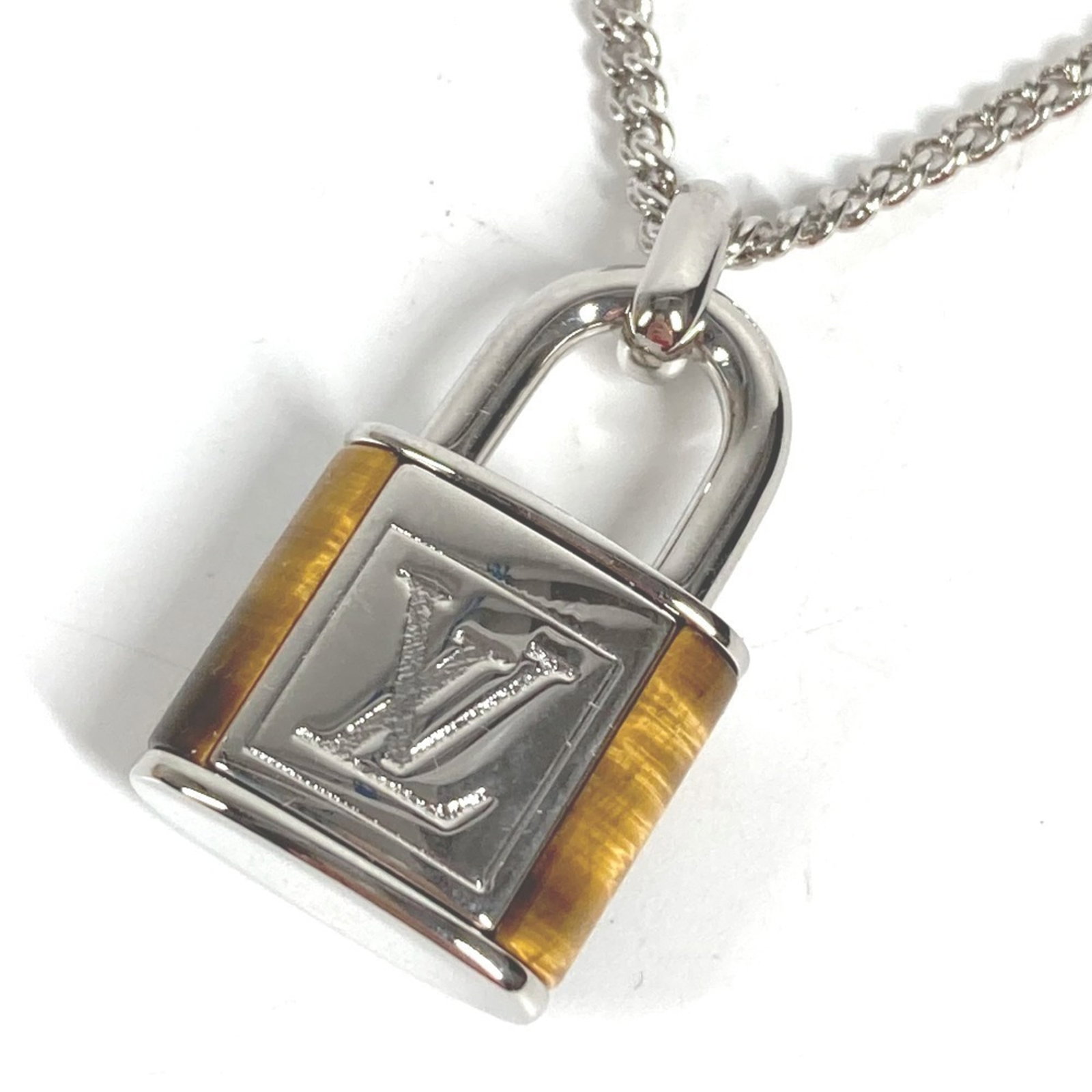 LOUIS VUITTON Metal: LOUIS VUITTON Metal Metal pendant from Louis Vuitton, featuring a brown and silver design, with a necklace circumference of 64.5 cm. This item is in like new condition, with only the faintest traces