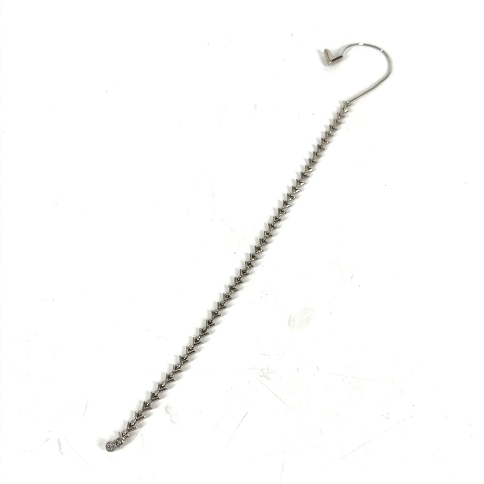 LOUIS VUITTON Earcuff Metal: LOUIS VUITTON Earcuff Metal Silver Louis Vuitton Earcuff with Rhinestone Stone, featuring a metal design with visible scratches and scuffs, is a unique and eye-catching accessory. The item bears a