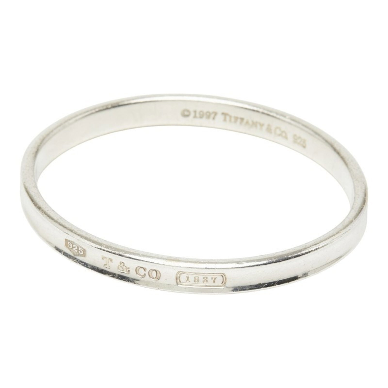 TIFFANY Bangle Silver 925: TIFFANY Bangle Silver 925 Silver bangle from the Tiffany 1837 Series, measuring 17.5cm in length and 6mm in width, features a sleek and modern design. The item is made from sterling silver (925) and b