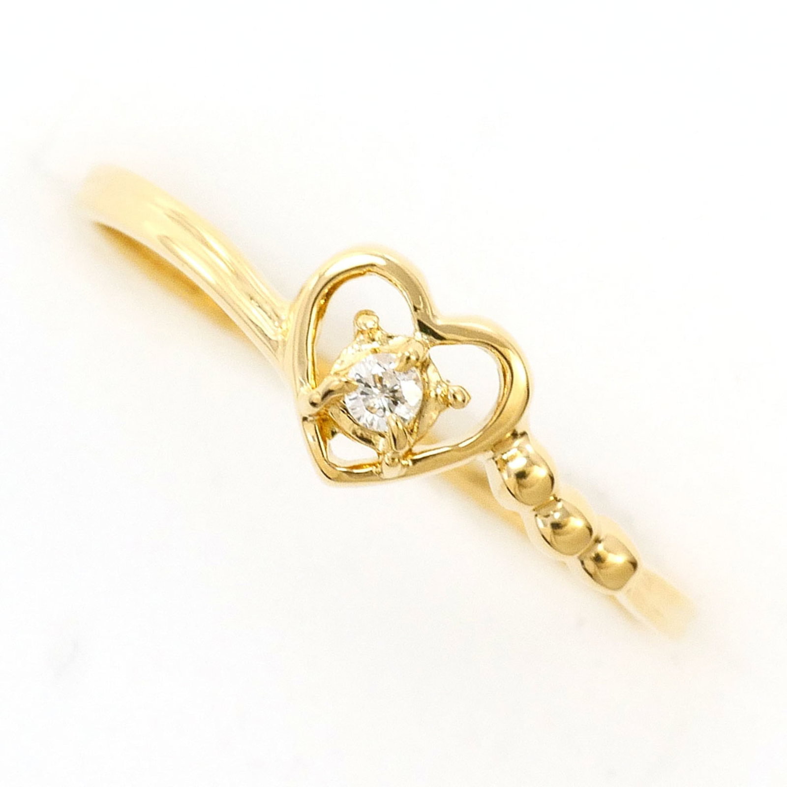 Band Ring Yellow Gold (18K): Band Ring Yellow Gold (18K) Yellow gold 18K band ring with a diamond stone, crafted from high-quality 18K gold, offers a touch of elegance to any outfit. Its slender 5mm width and 5.5 US size make it 