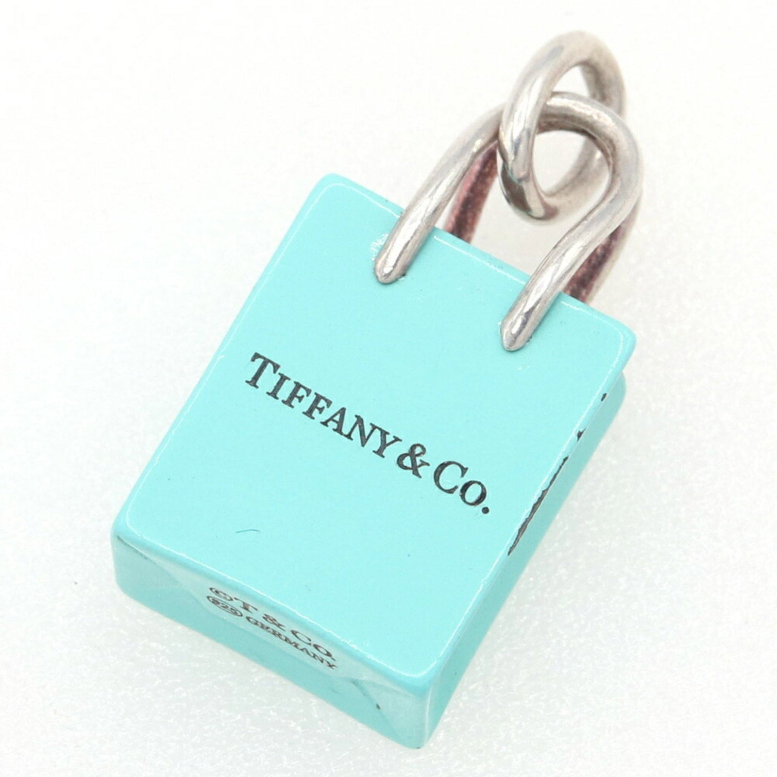 TIFFANY Sterling Silver 925: TIFFANY Sterling Silver 925 Sterling silver 925 pendant from Tiffany, featuring a blue hue and a touch of silver. The piece bears visible signs of wear, including scratches and scuffs, but remains ful