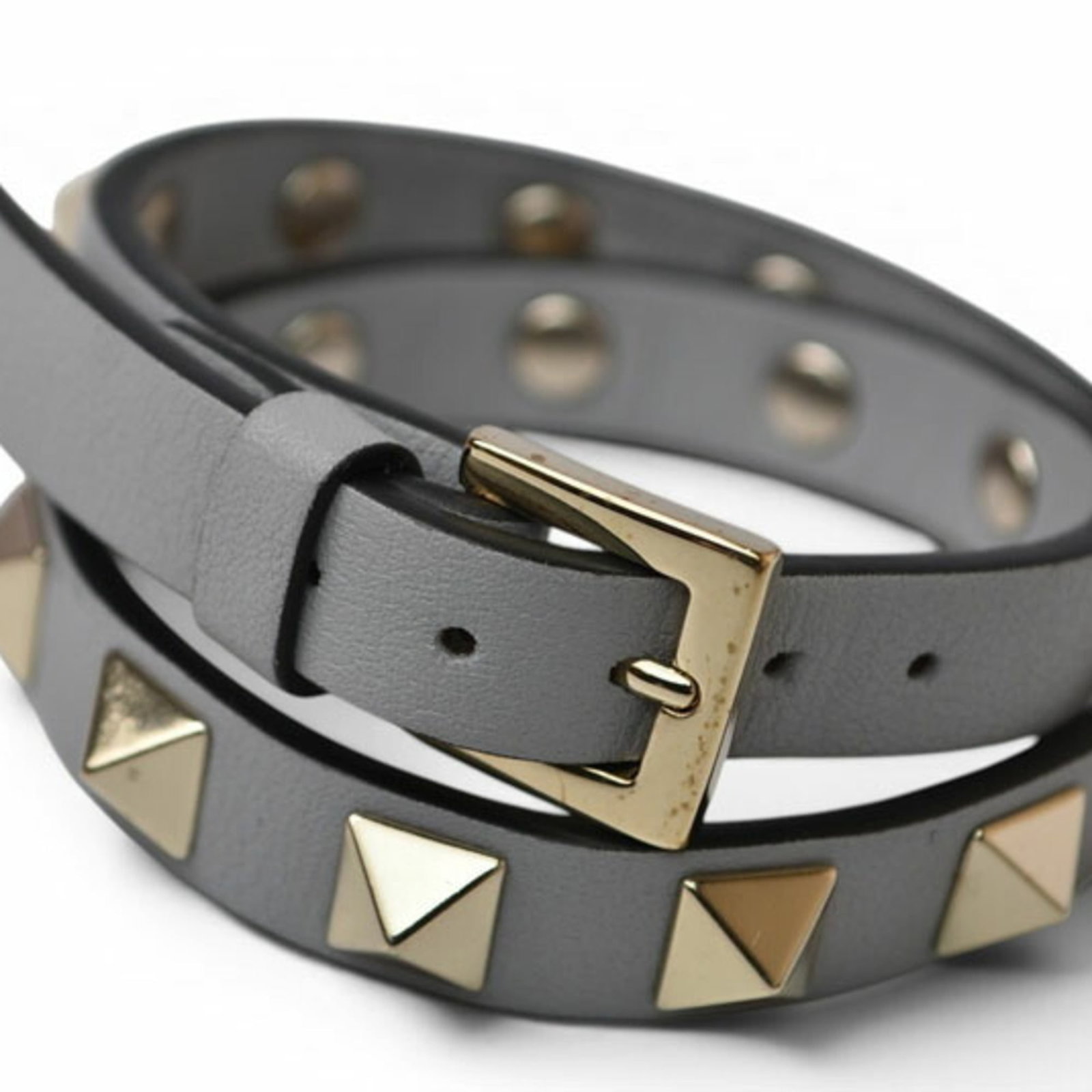 VALENTINO Bangle Leather: VALENTINO Bangle Leather The Valentino Bangle Leather is a stylish and versatile accessory, crafted from high-quality leather and featuring a sleek gray color. Measuring 13cm to 17cm in length, this b