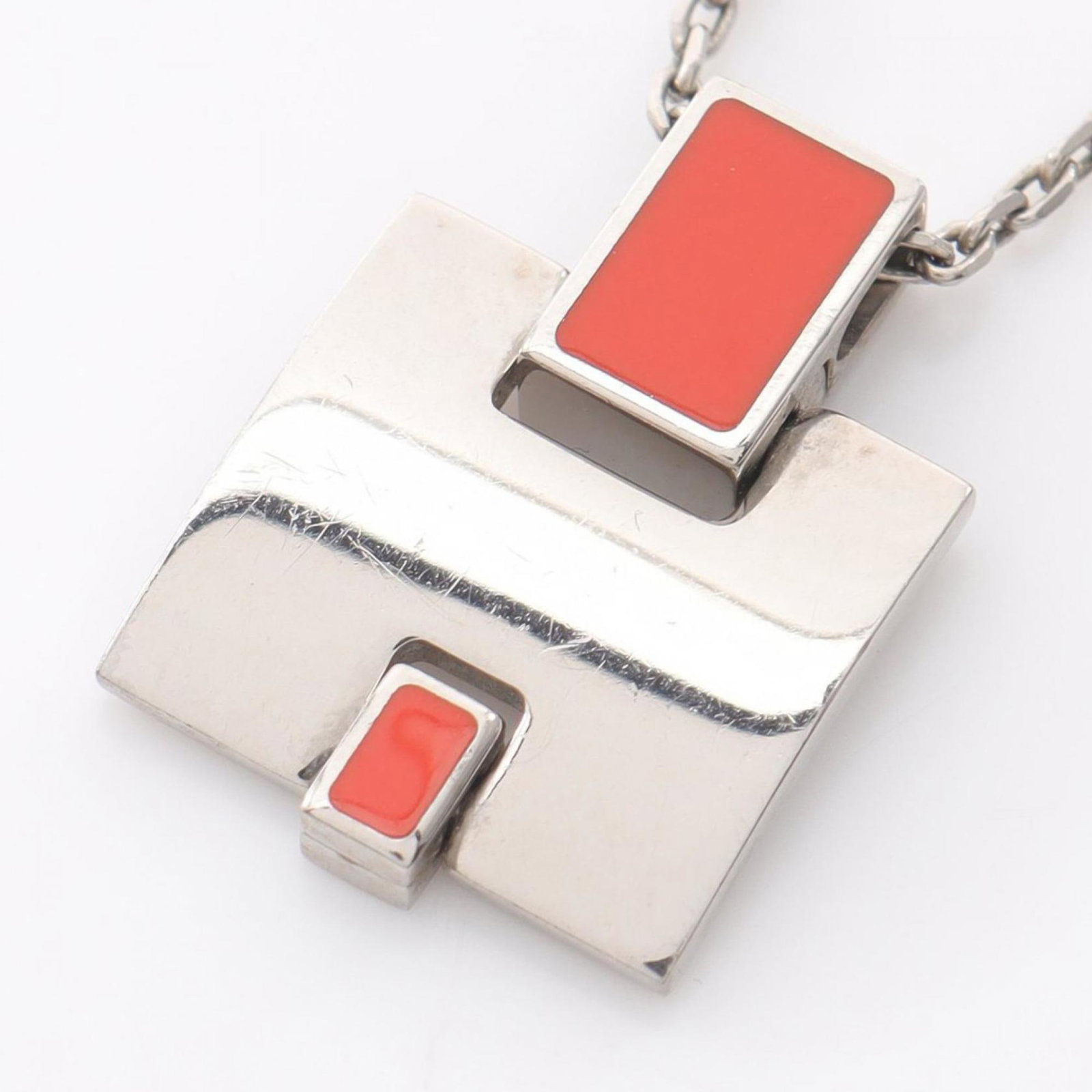 HERMES Stainless Steel: HERMES Stainless Steel Stainless steel pendant from Hermes Line, featuring a striking red color and silver accents, suspended from a durable stainless steel chain. The necklace measures 45 cm - 50 cm 