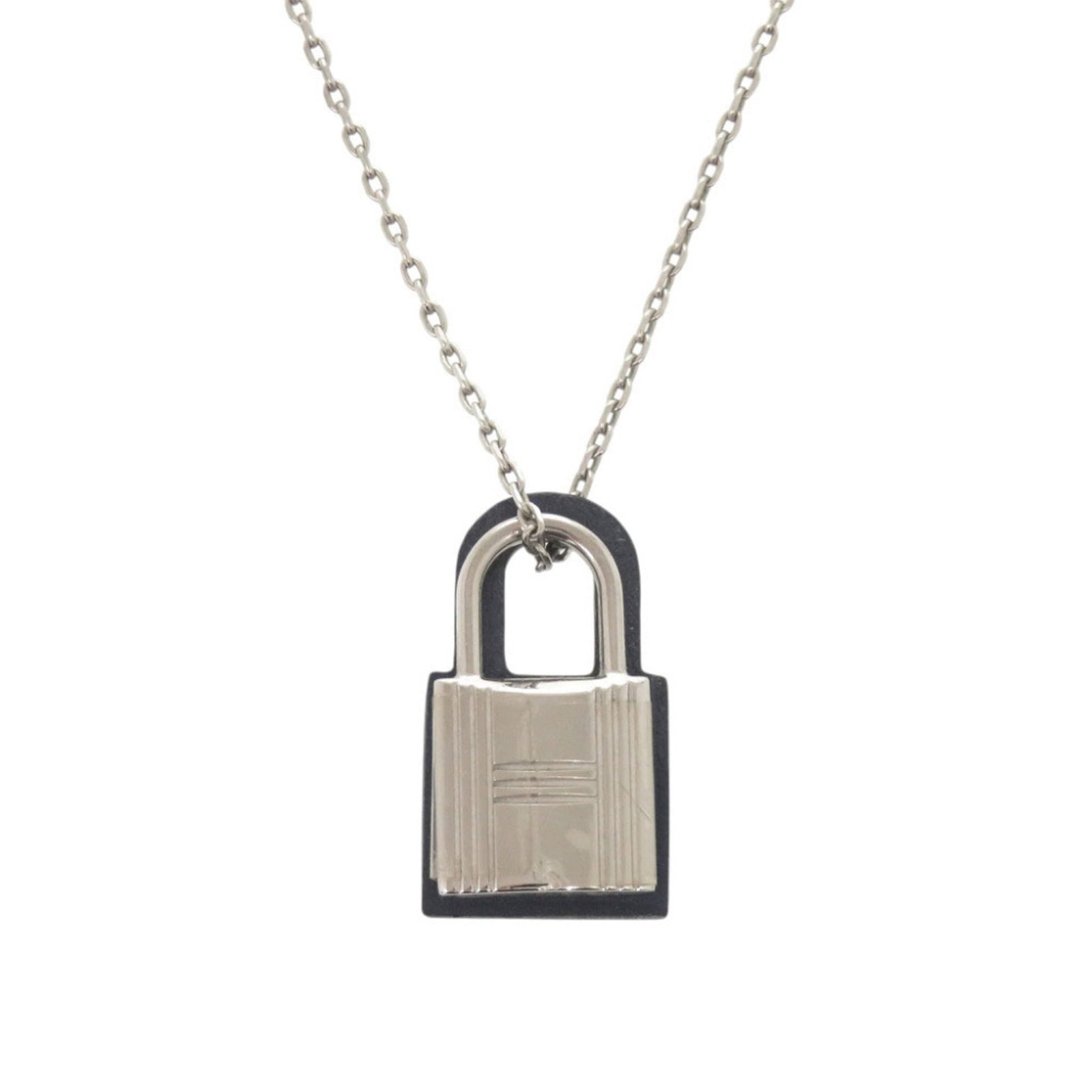 HERMES Metal Swift Leather: HERMES Metal Swift Leather Navy and silver Hermes Metal Swift Leather necklace, featuring a 25mm x 15mm pendant, is a stylish accessory for women. Made from metal and swift leather, this necklace
