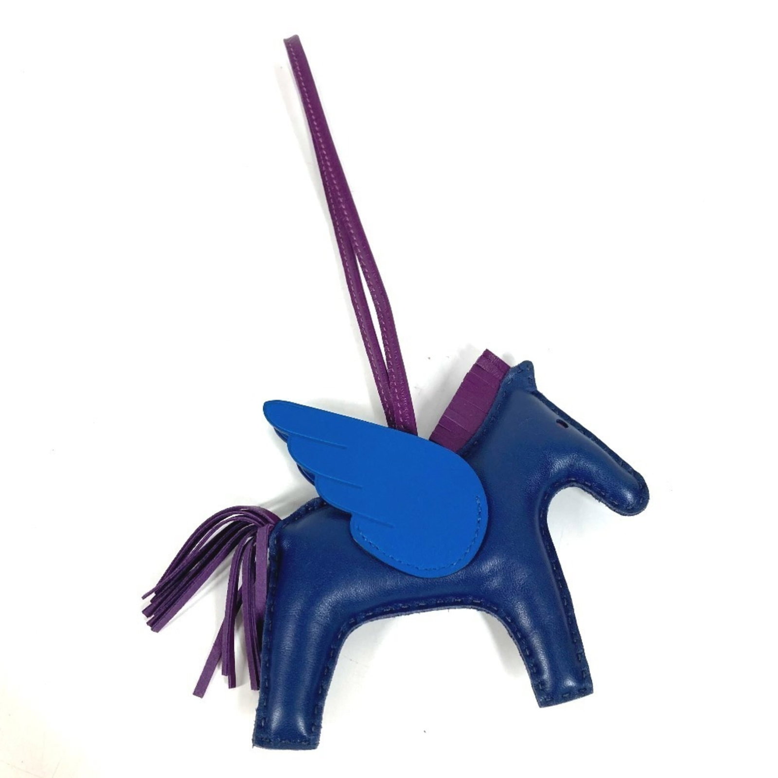HERMES Handbag Charm Agneau Milo: HERMES Handbag Charm Agneau Milo Agneau Milo is a high-quality material used in the construction of this Hermes handbag charm. The charm features a striking blue and purple color combination,