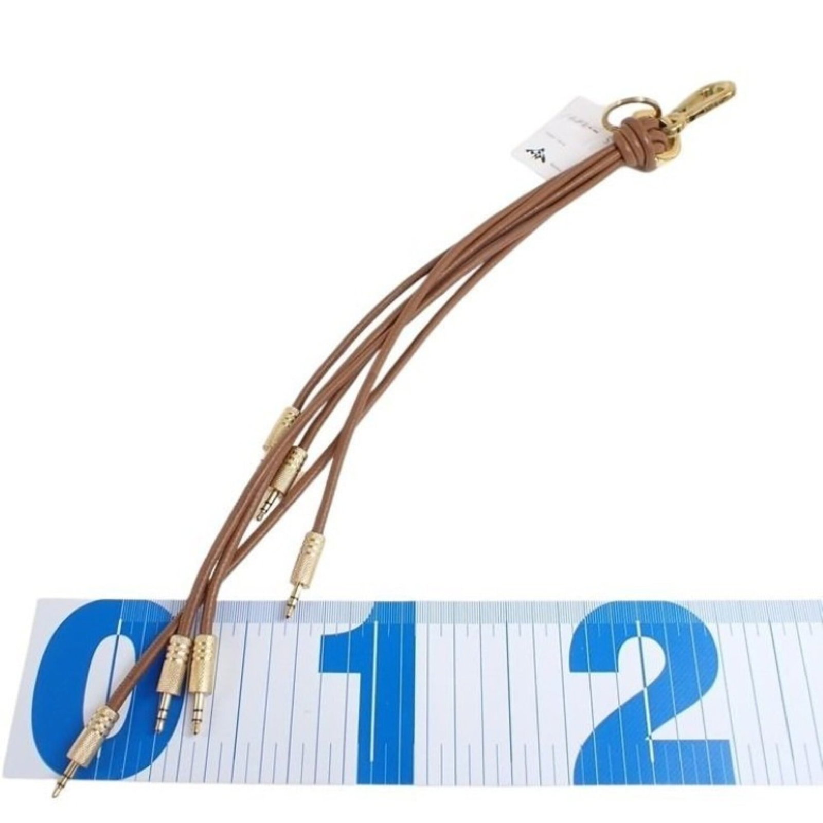 LOEWE Handbag Charm Leather: LOEWE Handbag Charm Leather This brown Loewe handbag charm is made from high-quality leather and features a distinctive design. It has visible scratches and scuffs, giving it a worn, vintage look, and