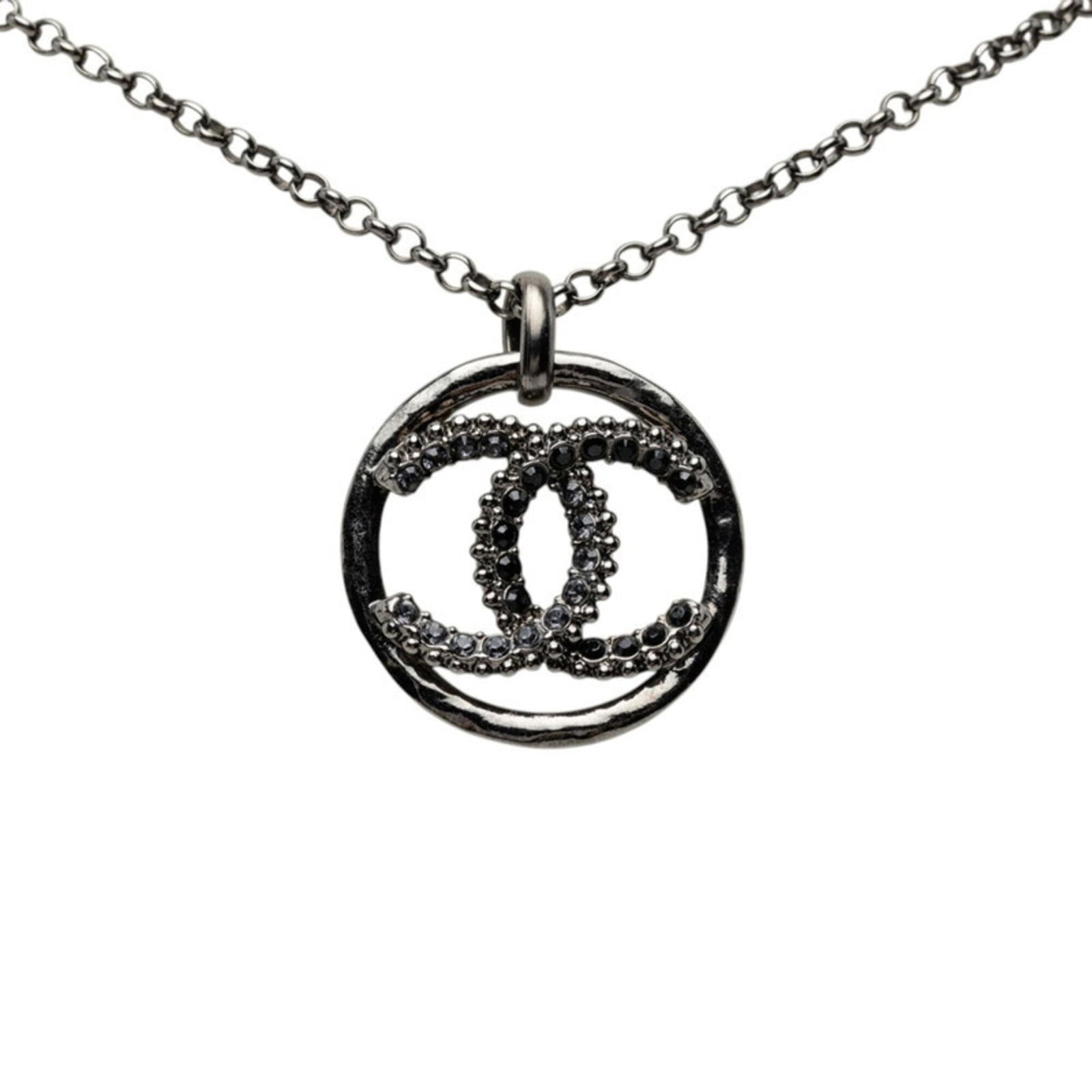 CHANEL Metal Rhinestone: CHANEL Metal Rhinestone Metal Rhinestone Pendant from Chanel, featuring a striking black metal and rhinestone design. The pendant measures 28.3mm x 24.2mm and is attached to a 61 cm chain, making it a