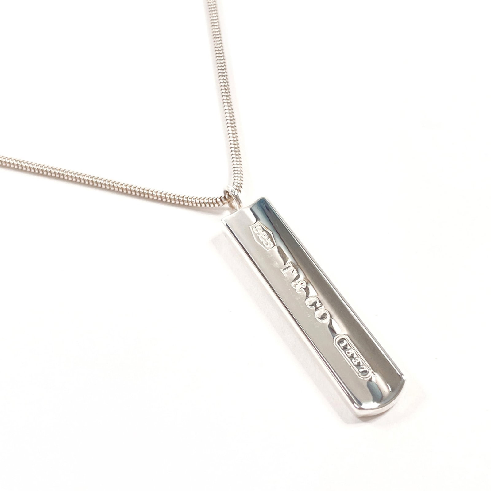 TIFFANY Silver 925: TIFFANY Silver 925 Silver 925 Tiffany Necklace Pendant. This gently used silver 925 pendant necklace features a 40.6mm x 8.2mm pendant with a 45cm neck circumference, bearing minor scratches or light