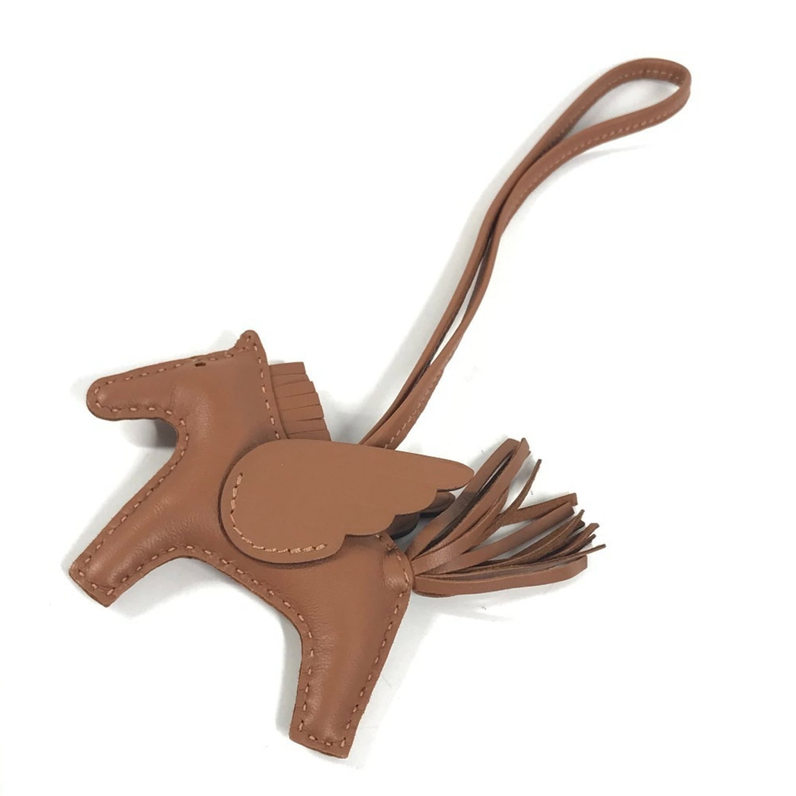 HERMES Handbag Charm Agneau Milo: HERMES Handbag Charm Agneau Milo Agneau Milo is a high-quality material used in the construction of this Hermes Handbag Charm. The brown color and like-new condition make it a desirable accessory for