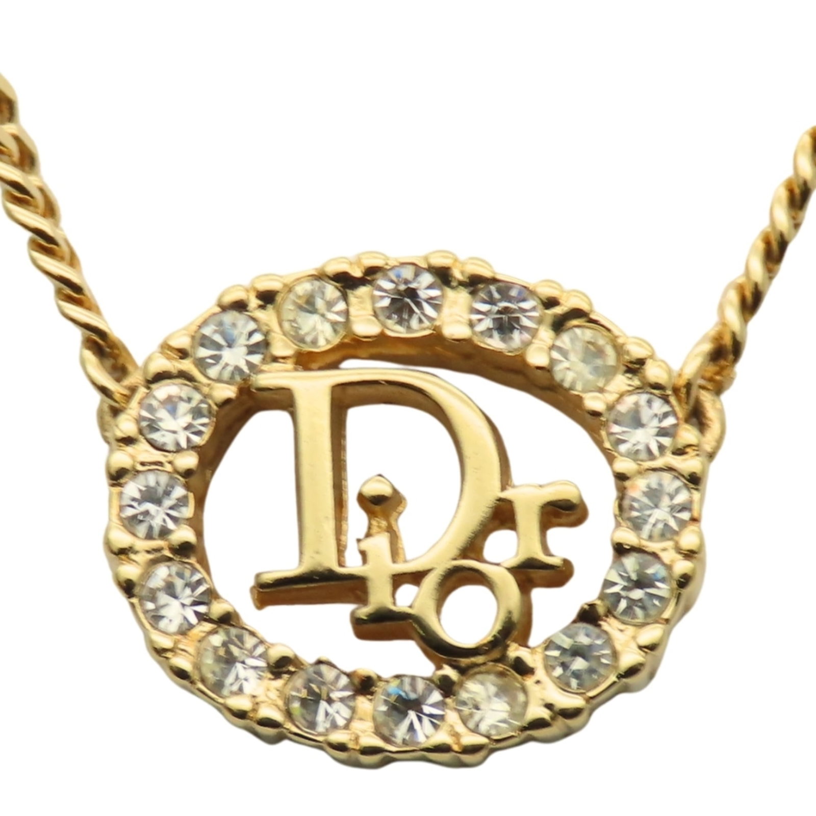 CHRISTIAN DIOR Metal: CHRISTIAN DIOR Metal Gently used Christian Dior gold metal necklace featuring a rhinestone pendant, with a 42.5 cm chain circumference and a 13.7mm x 15.9mm pendant size. The necklace is in very good 
