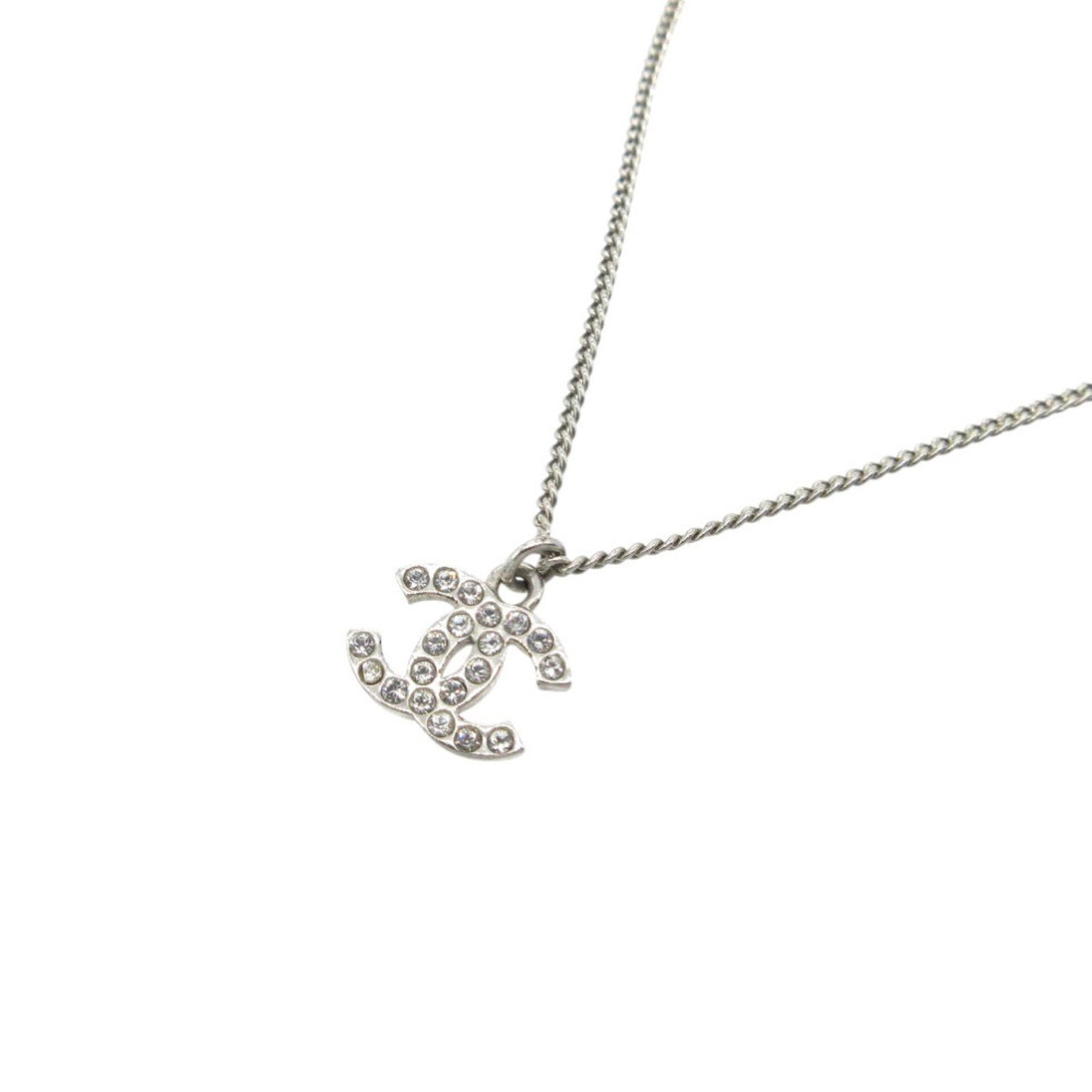 CHANEL Metal Rhinestone: CHANEL Metal Rhinestone Silver Metal Rhinestone Necklace from Chanel, featuring a notable metal and rhinestone design, bearing a signature. The necklace has visible wear, scratches, and scuffs, but re