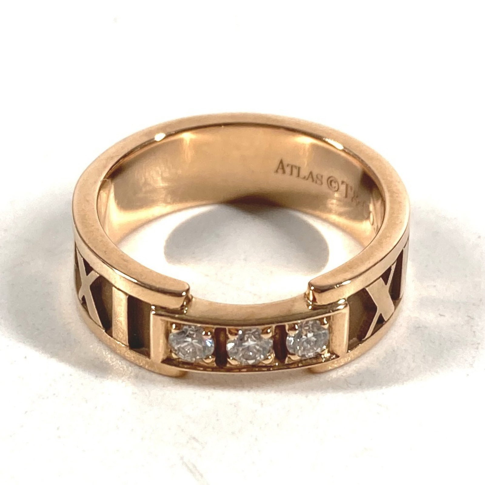 TIFFANY Band Ring Pink Gold (18K): TIFFANY Band Ring Pink Gold (18K) Pink gold 18K band ring from Tiffany's Atlas line, featuring a diamond stone and a classic design. This gently used ring shows minor signs of wear, with small scratch