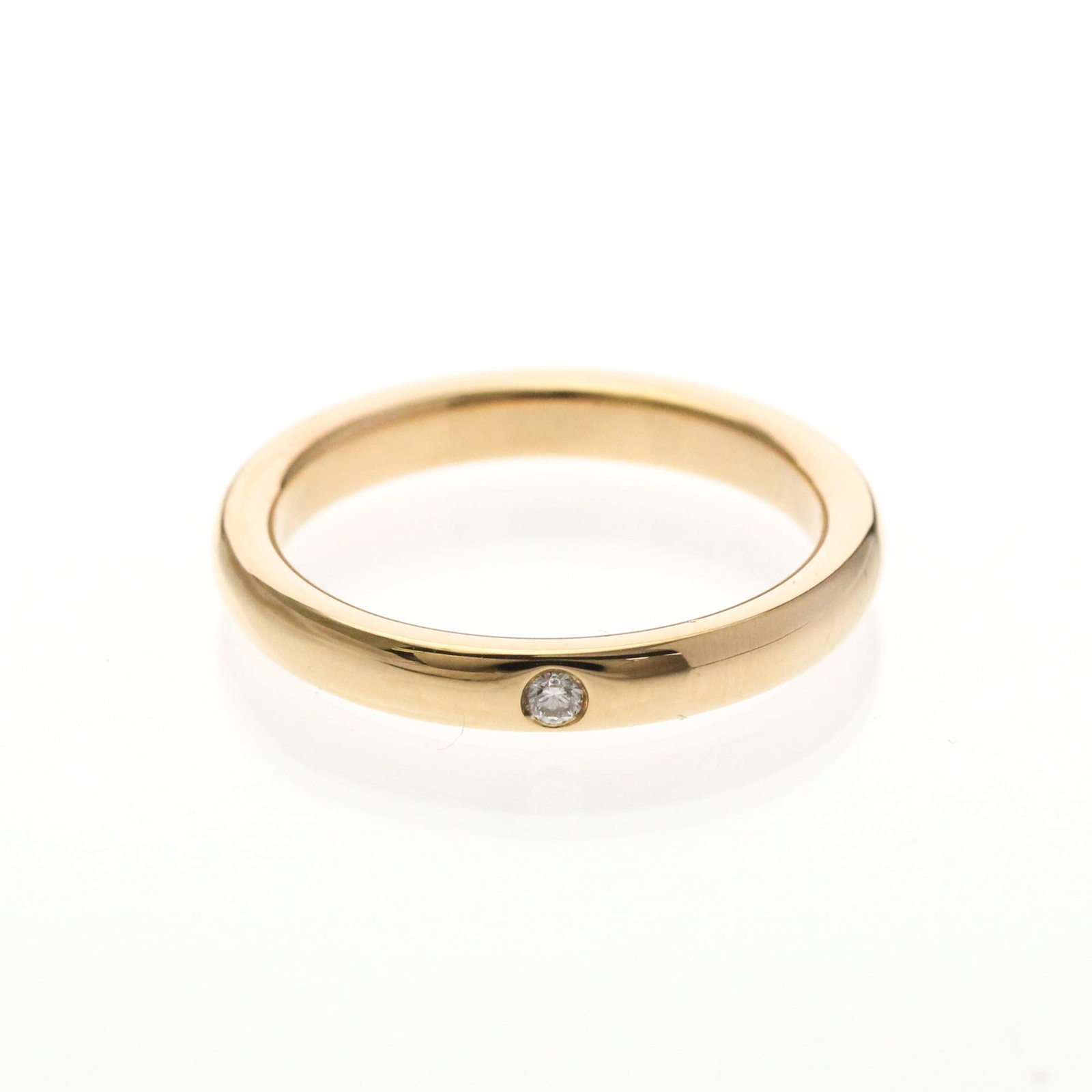 TIFFANY Band Ring Pink Gold (18K): TIFFANY Band Ring Pink Gold (18K) Pink gold band ring featuring a 1P diamond, crafted from 18K metal, with a US size 5 fit and a width of 2.7mm. This gently used stacking band ring showcases a subtle 