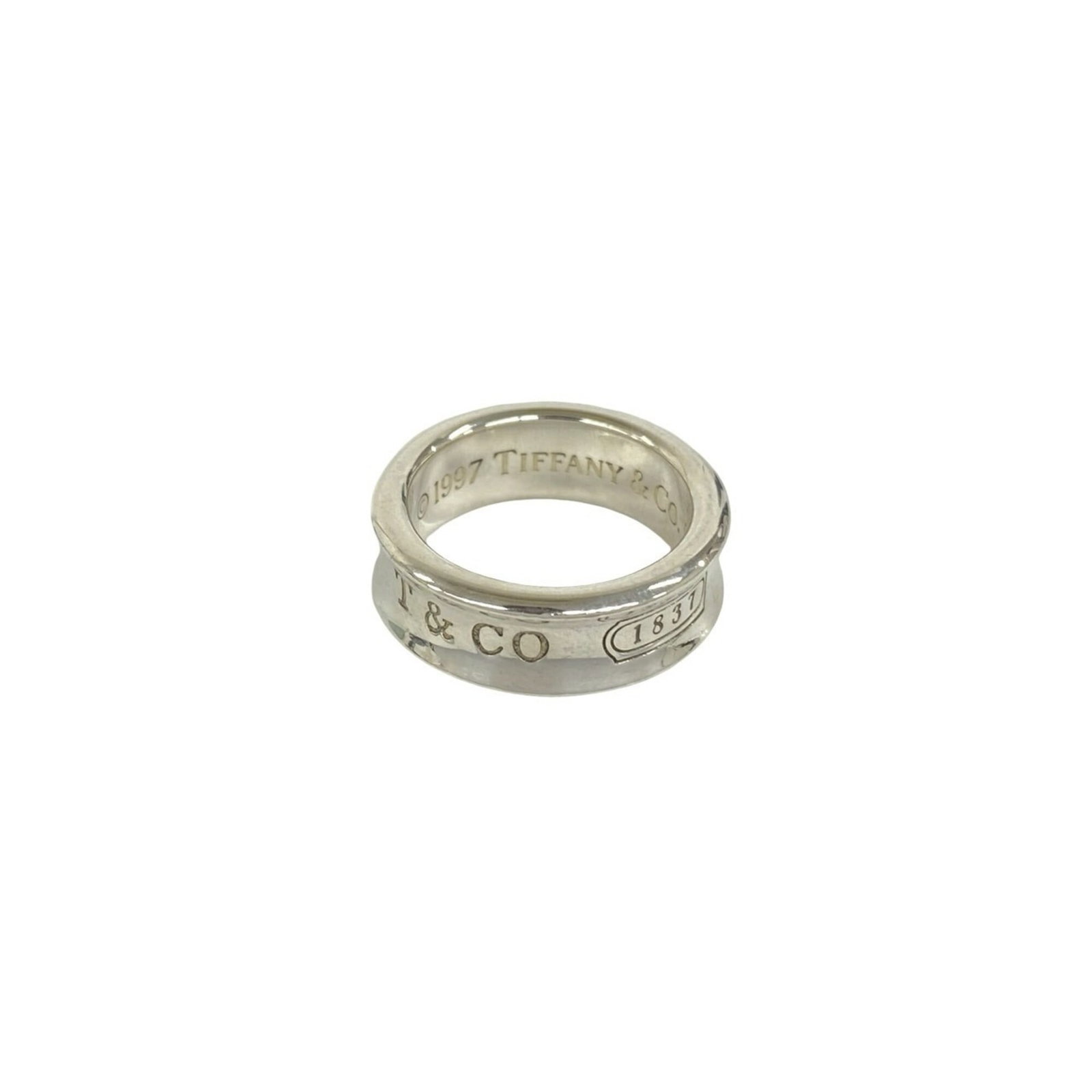 TIFFANY Band Ring Silver 925: TIFFANY Band Ring Silver 925 Silver 925 band ring from Tiffany, a classic design featuring a sleek and modern silhouette. The item bears visible signs of wear, including scratches and scuffs, but rema