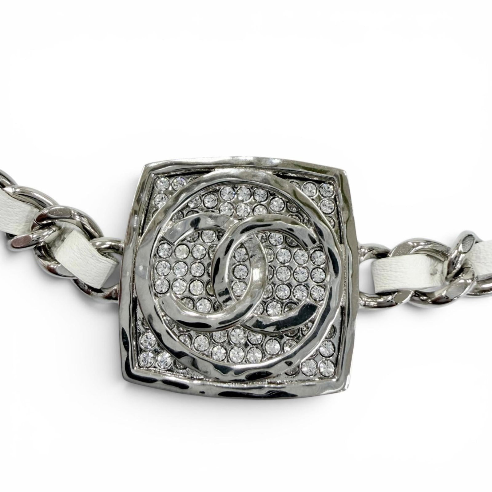 CHANEL Leather Silver White: CHANEL Leather Silver White Silver and white leather necklace with a rhinestone pendant, featuring a sleek design and elegant style. The 20mm x 20mm pendant is set in a sturdy chain with a silver fini