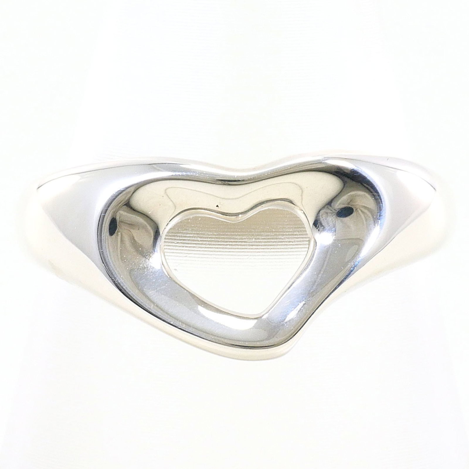 TIFFANY Band Ring Silver: TIFFANY Band Ring Silver Silver band ring from Tiffany featuring an open heart design, crafted from high-quality silver with a US size 6.5 and 9mm width. This like-new used ring boasts excellent