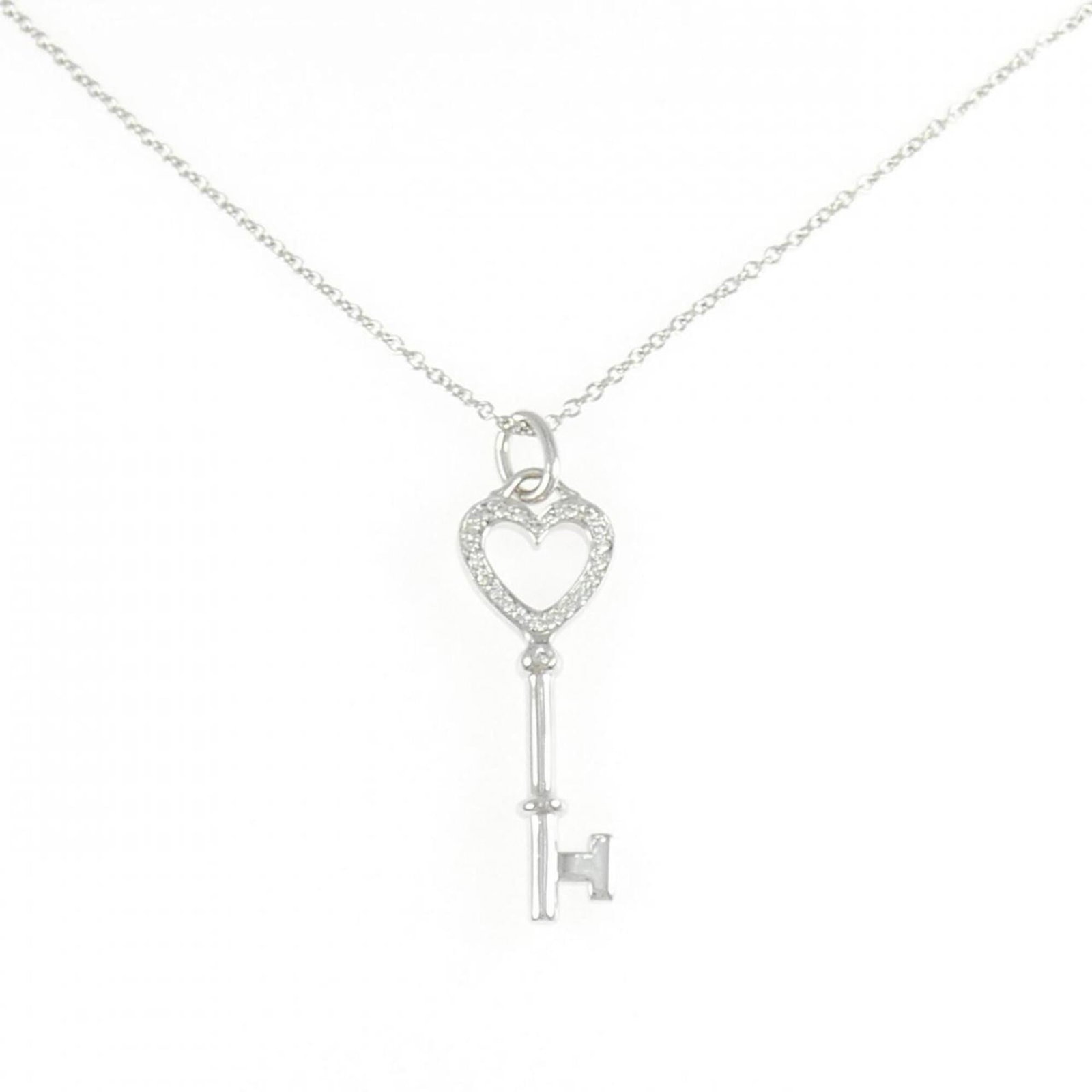 TIFFANY White Gold (18K): TIFFANY White Gold (18K) Tiffany's iconic 18K white gold pendant shines with elegance, boasting a sleek design that complements any style. Measuring 30.6mm x 9.1mm, this pendant features a timeless