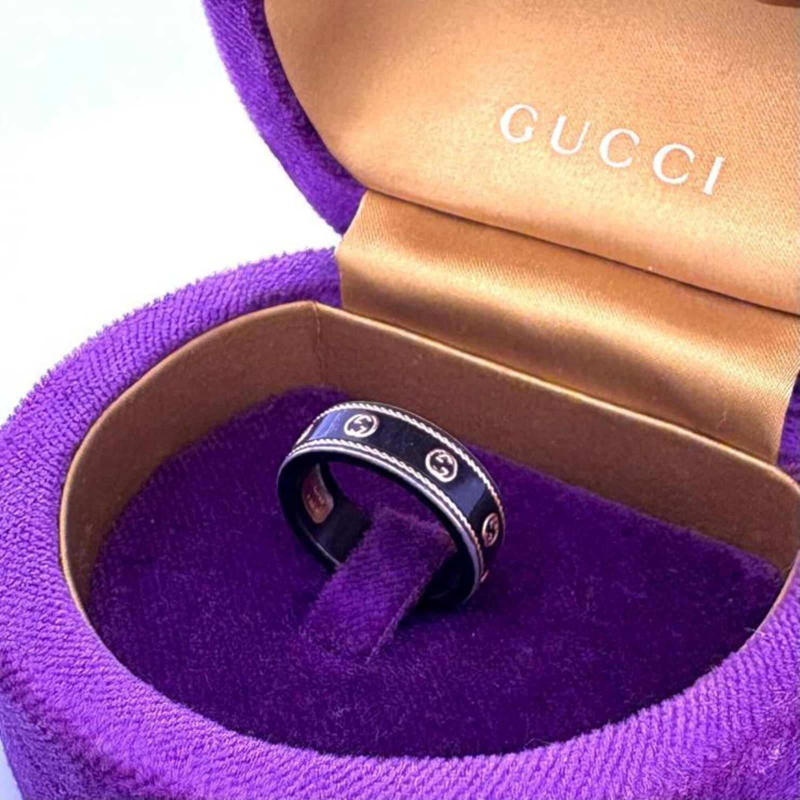 GUCCI Band Ring Gold (18K): GUCCI Band Ring Gold (18K) This 18K gold band ring from Gucci boasts a sleek, black design that adds a touch of sophistication to any outfit. The ring features visible wear and minor scratches, but