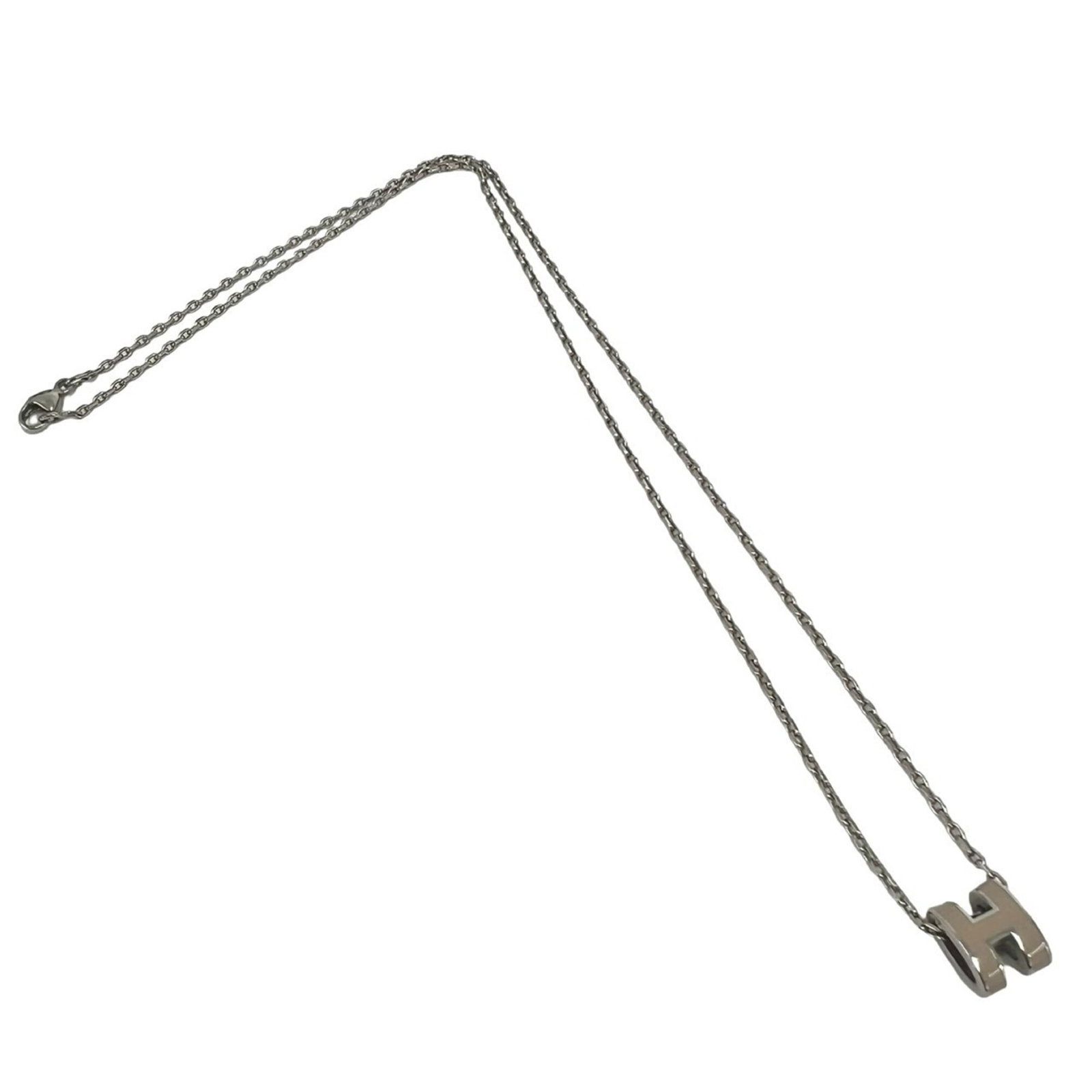 HERMES Metal Beige Silver: HERMES Metal Beige Silver The Hermes Metal Beige Silver necklace features a 9mm x 7mm pendant with a beige and silver finish, set on a metal chain with a 41.2 cm circumference. This used necklace has