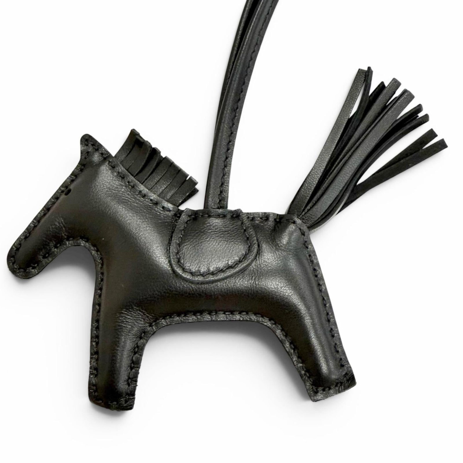 HERMES Handbag Charm Agneau Milo: HERMES Handbag Charm Agneau Milo Agneau Milo is a high-quality material used in this Hermes handbag charm, adding a touch of luxury to its design. The charm's sleek black color and precise dimensions