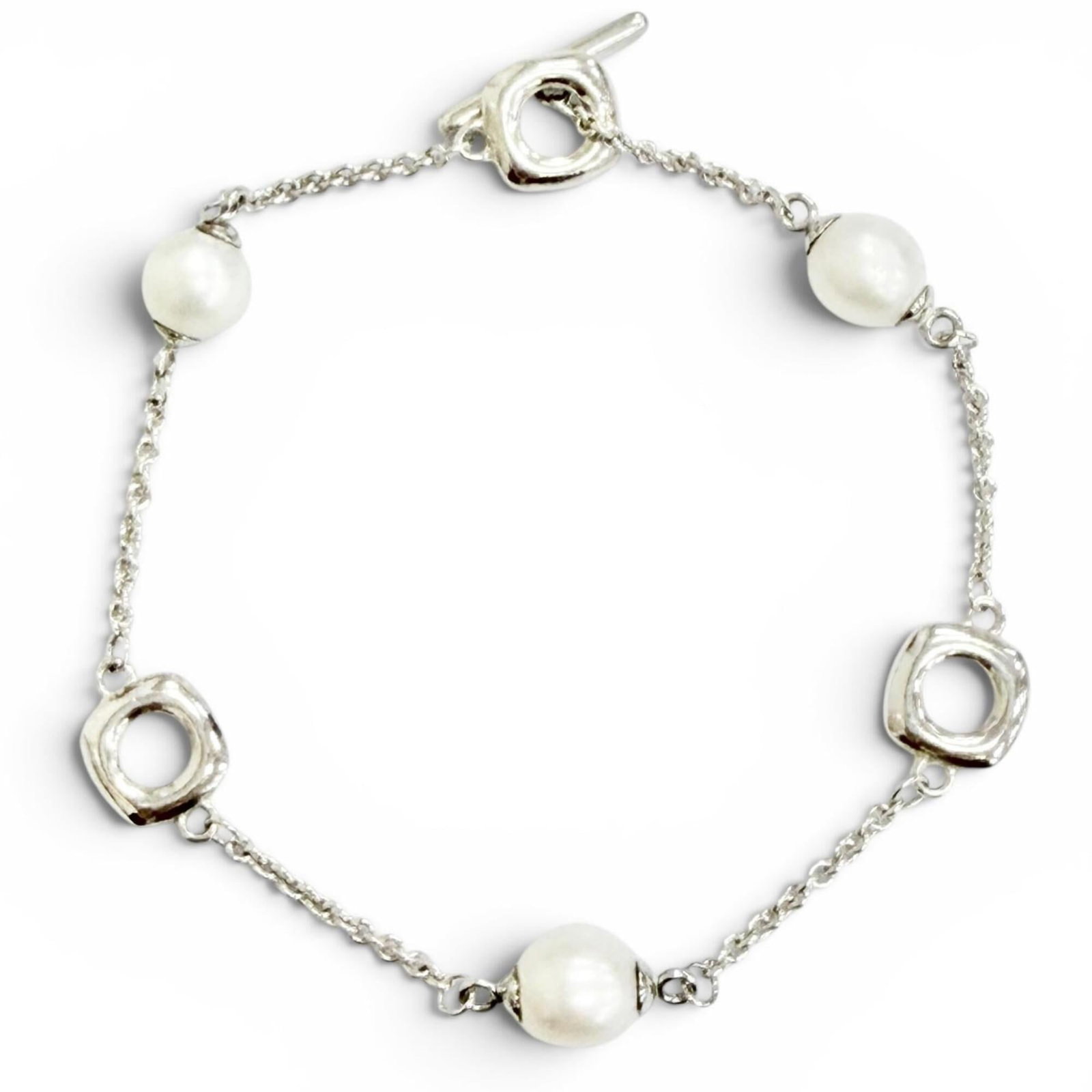 TIFFANY Charm Bracelet Silver 925: TIFFANY Charm Bracelet Silver 925 Silver 925 Tiffany charm bracelet with a fresh freshwater pearl, available in a 16cm length. This gently used bracelet features minor signs of wear, including small s