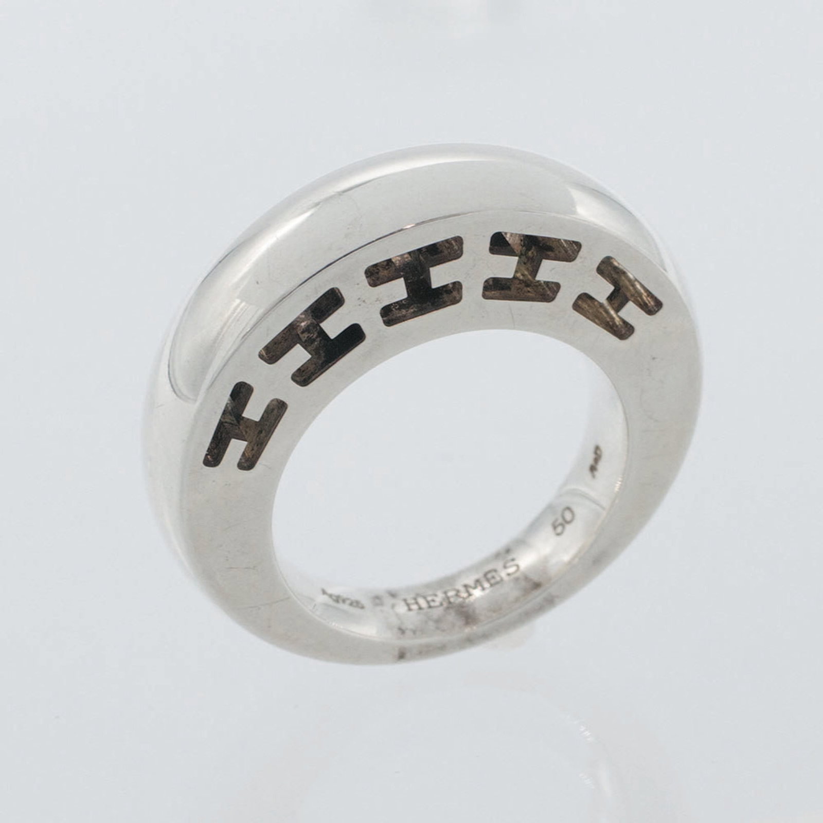 HERMES Band Ring Sterling Silver 925: HERMES Band Ring Sterling Silver 925 Sterling silver 925 band ring from Hermes features a sleek design. Gently used with minor signs of wear, this item is in very good condition, bearing small