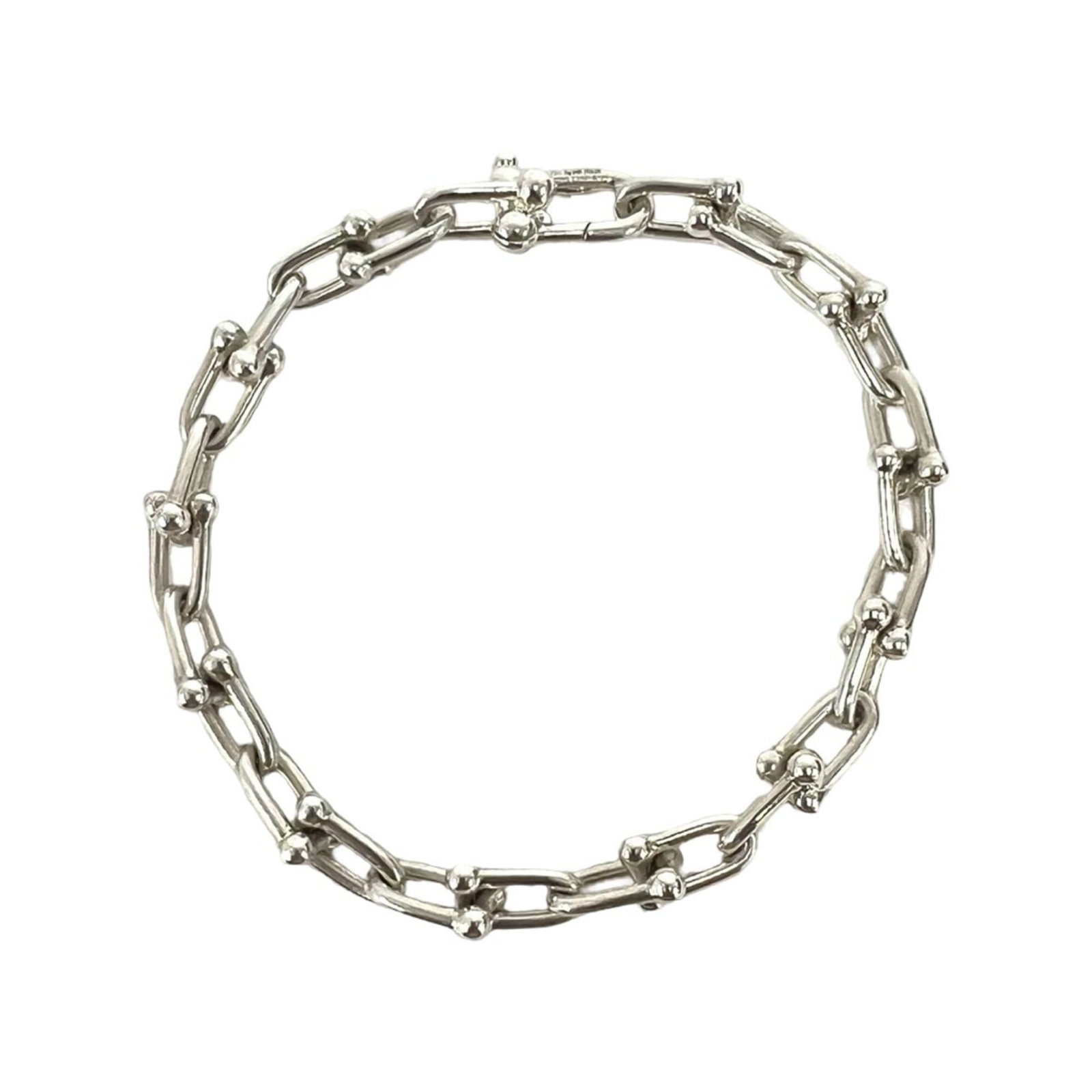 TIFFANY Charm Bracelet Silver 925: TIFFANY Charm Bracelet Silver 925 Silver 925 charm bracelet from Tiffany, featuring a silver 925 chain with visible scratches and scuffs, measuring 17cm in length. This charm bracelet is in good used
