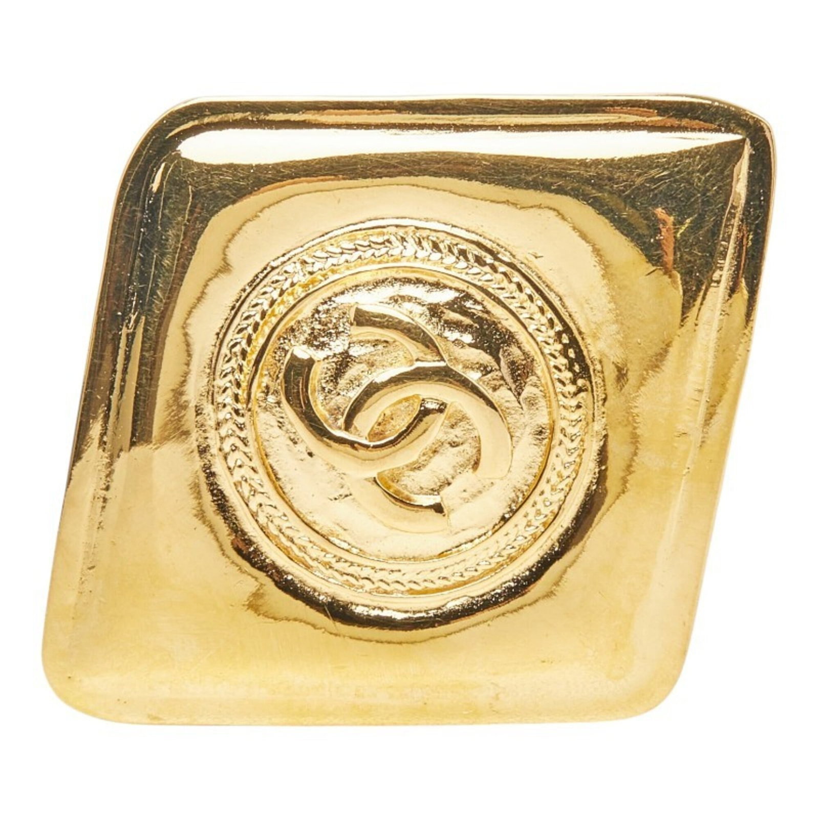 CHANEL Brooch Gold Plating: CHANEL Brooch Gold Plating Gold plating gives this CHANEL brooch a luxurious touch, while visible scratches and scuffs add a touch of wear and character. The brooch measures 4.81cm x 4.04cm and is