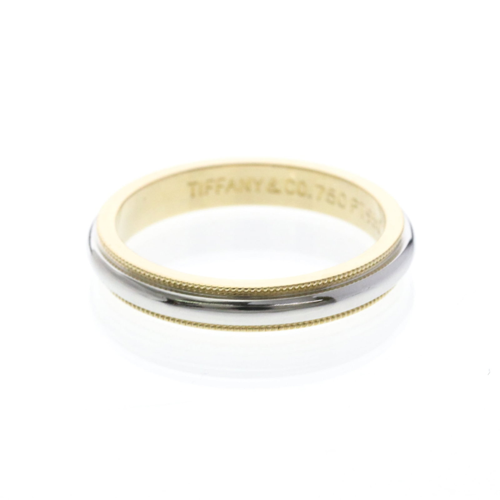 TIFFANY Band Ring Platinum Yellow Gold (18K): TIFFANY Band Ring Platinum Yellow Gold (18K) Platinum yellow gold (18K) band ring with intricate milgrain details, adding a touch of vintage elegance to any outfit. This Tiffany band ring features a s