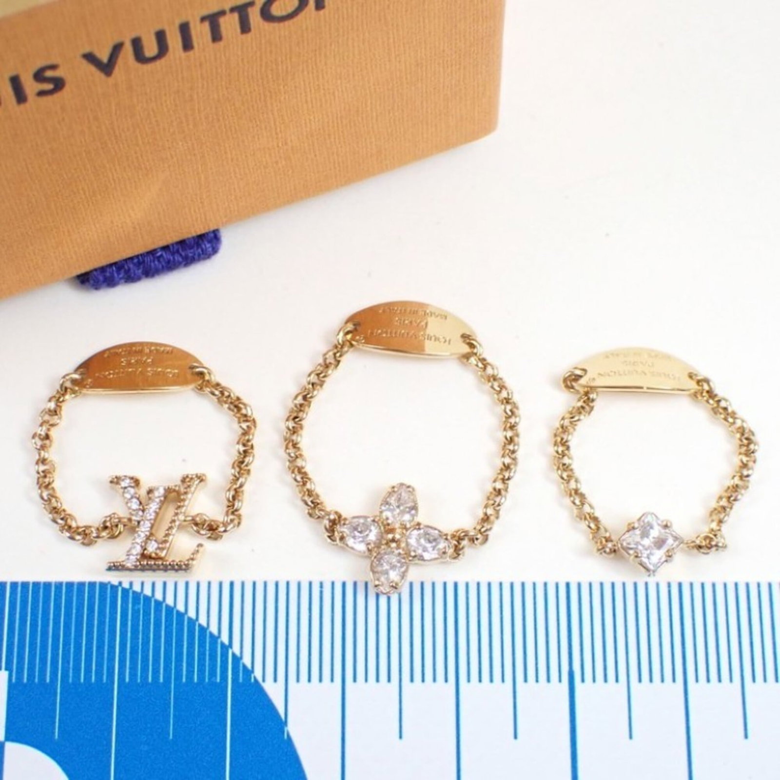 LOUIS VUITTON Band Ring Metal: LOUIS VUITTON Band Ring Metal Made from metal, this Louis Vuitton Band Ring features a gold finish and bears a signature. The item is a band ring, available in a US size of 7.5, and is in very good co