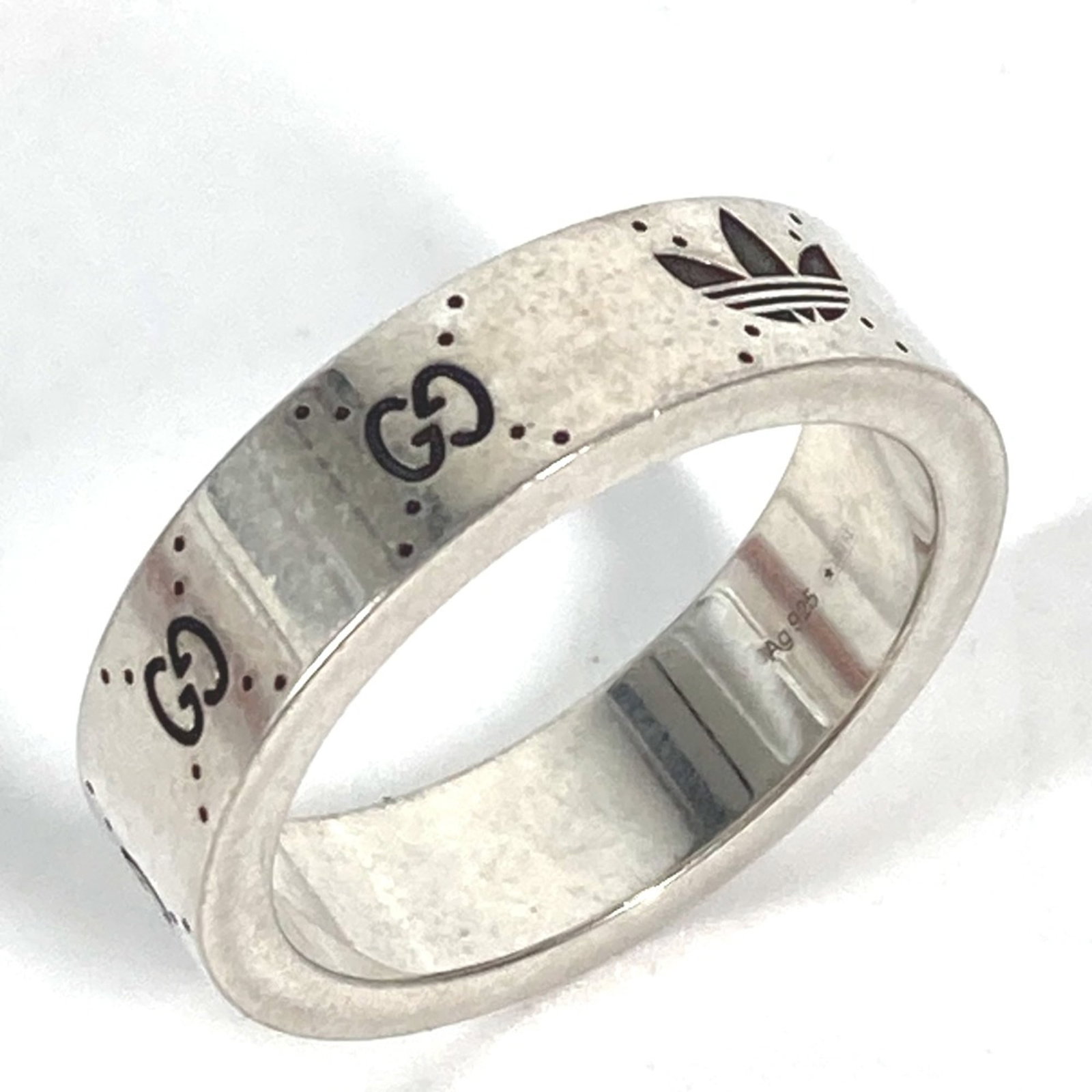 GUCCI Band Ring Silver: GUCCI Band Ring Silver The Gucci Band Ring Silver is a sleek and modern accessory featuring a silver band with a signature from the artist. This band ring is made from high-quality silver and is in go