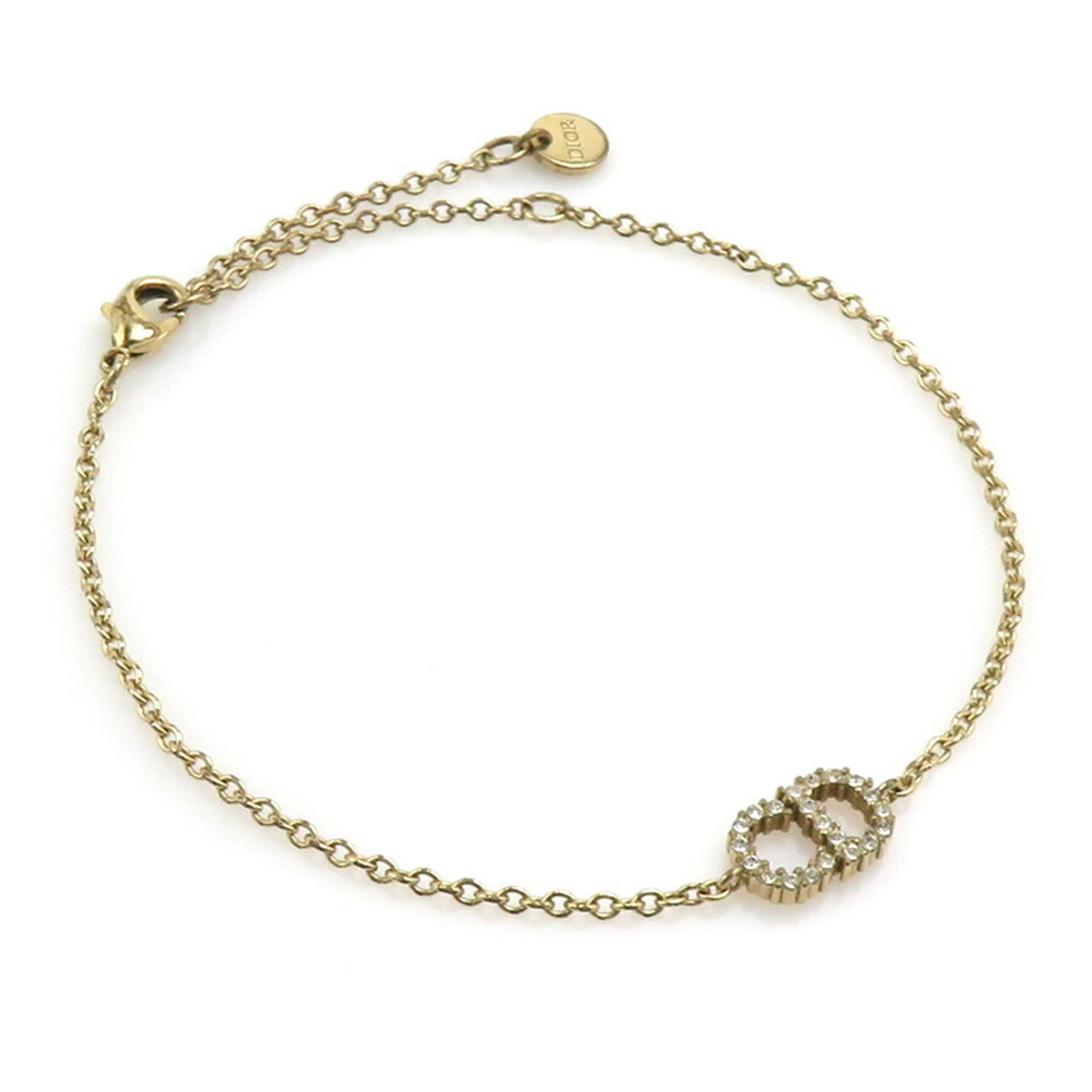 CHRISTIAN DIOR Charm Bracelet Metal: CHRISTIAN DIOR Charm Bracelet Metal The Christian Dior charm bracelet is a gold metal piece with a 22cm length, bearing visible scratches and scuffs. This charm bracelet is made of metal and features