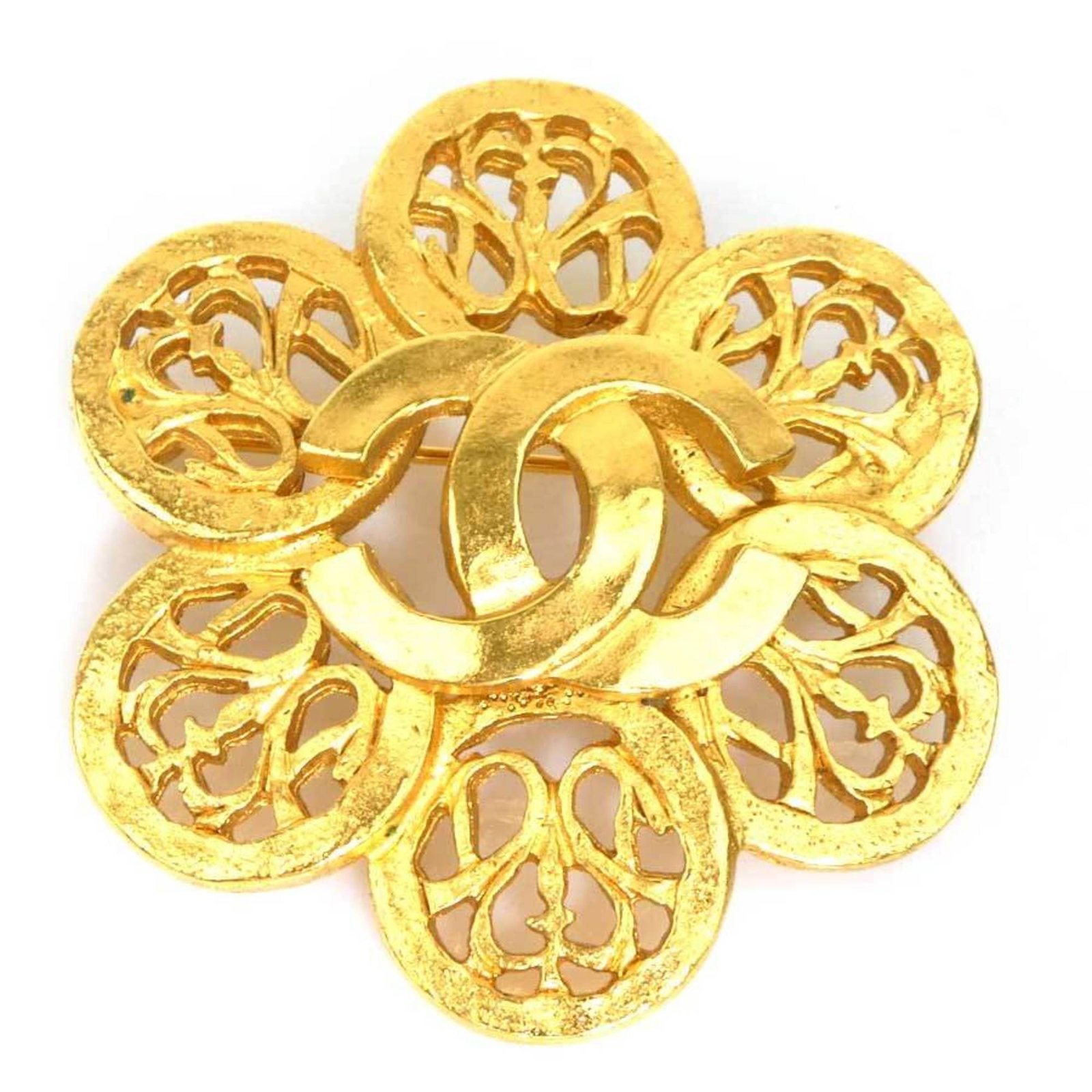 CHANEL Brooch Metal: CHANEL Brooch Metal Gold Chanel Brooch. Made in France, this metal brooch features a classic design with visible wear and scratches. Measuring 5cm x 5cm, it is a small, elegant accessory. Item Specifi