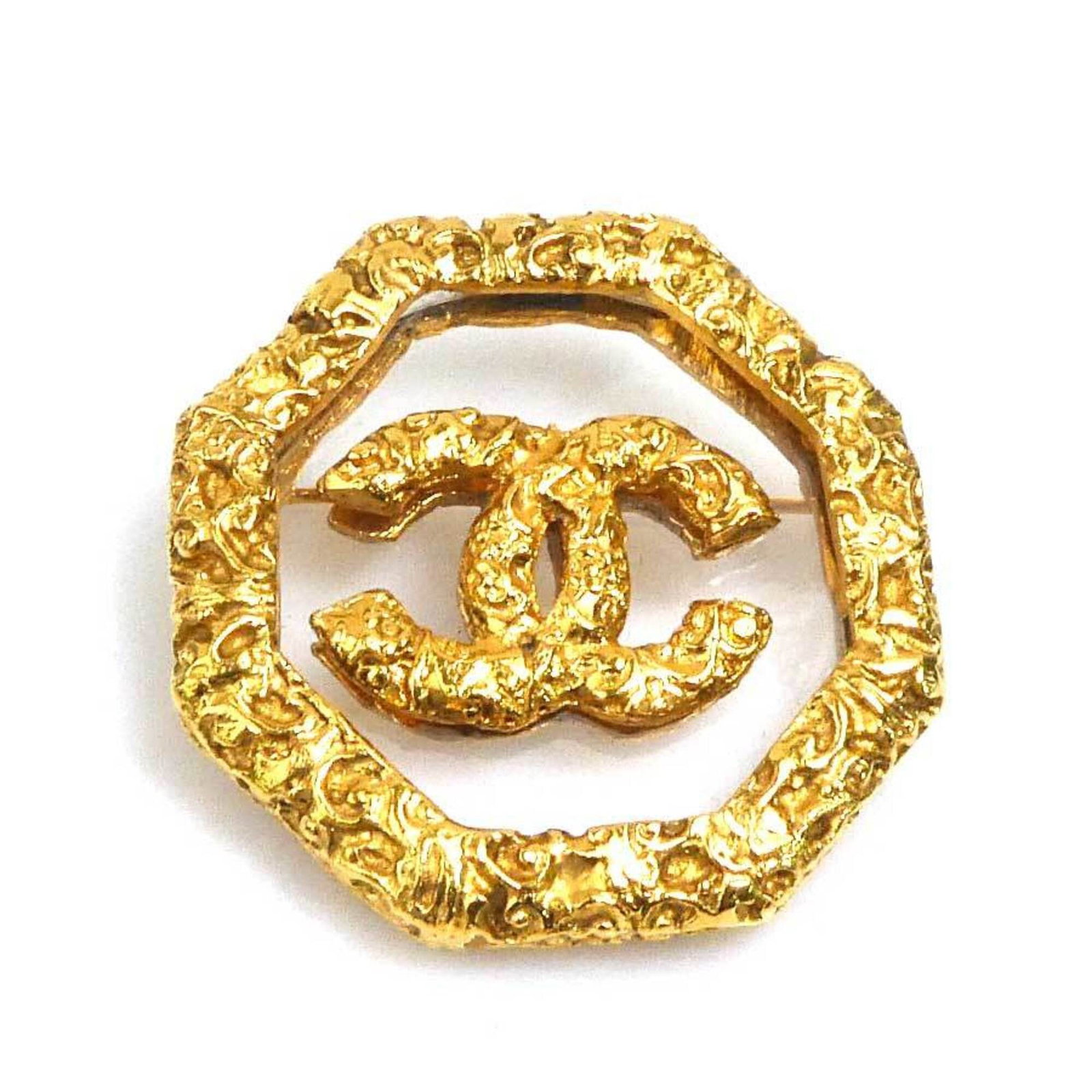 CHANEL Brooch Metal: CHANEL Brooch Metal Gold Chanel Brooch - 4.2cm x 4cm / 1.65'' x 1.57'' - France. This gold Chanel brooch features metal construction and bears a signature. It has visible wear with scratches, scuffs,