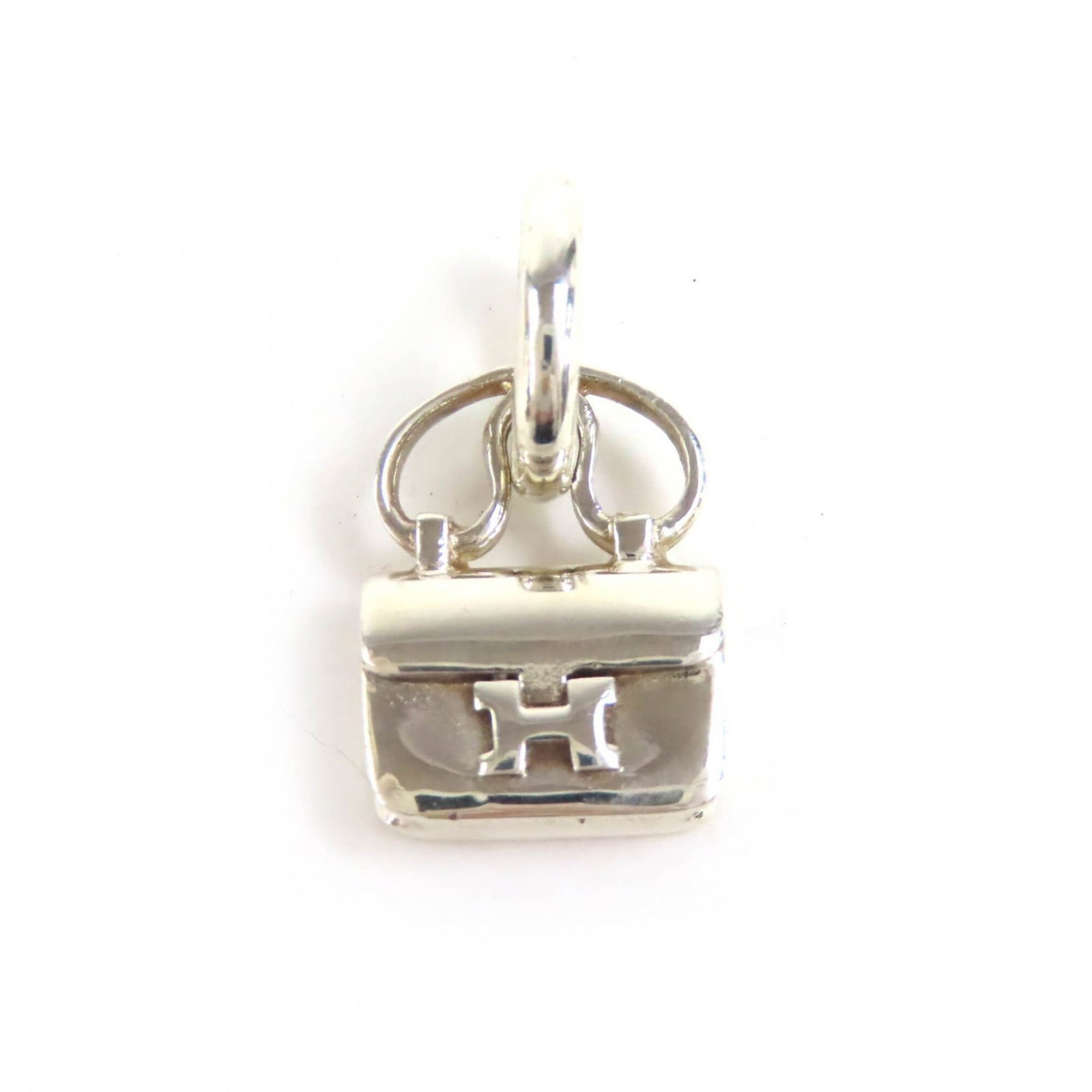 HERMES Silver 925: HERMES Silver 925 Silver 925 pendant from Hermes, featuring a 22mm x 13mm amulet with a gentle patina, bearing minor scratches and light marks. This gently used pendant weighs 6.6g and is made from hi