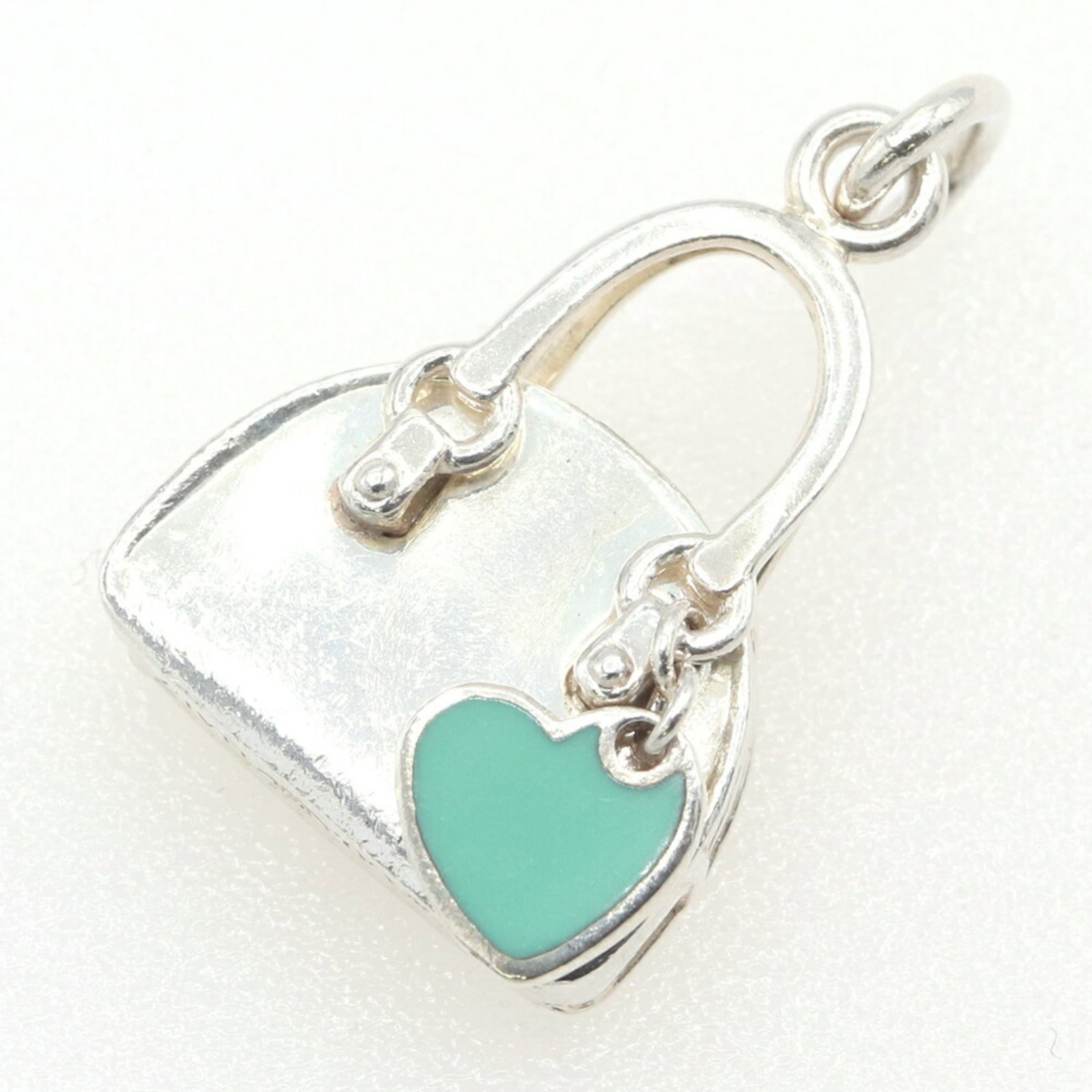 TIFFANY Sterling Silver 925: TIFFANY Sterling Silver 925 Sterling silver 925 pendant from Tiffany, featuring a blue hue and a touch of silver. The piece bears visible signs of wear, including scratches and scuffs, but remains ful
