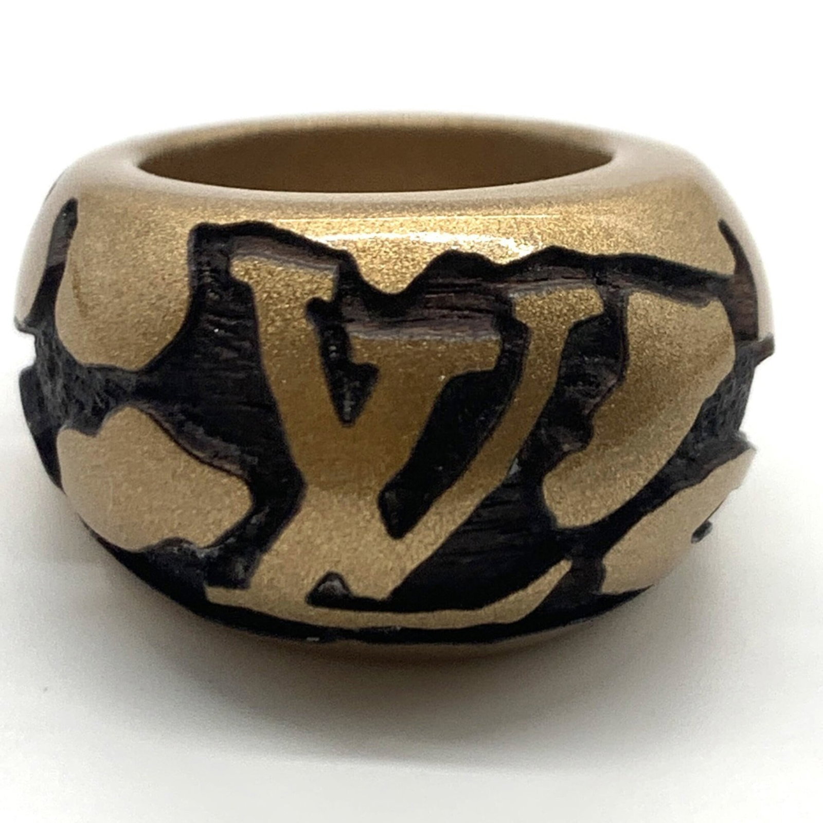 LOUIS VUITTON Band Ring Wood: LOUIS VUITTON Band Ring Wood The Louis Vuitton Band Ring Wood features a unique wooden design with a metallic finish, showcasing the brand's signature style. This band ring boasts a distinctive wood