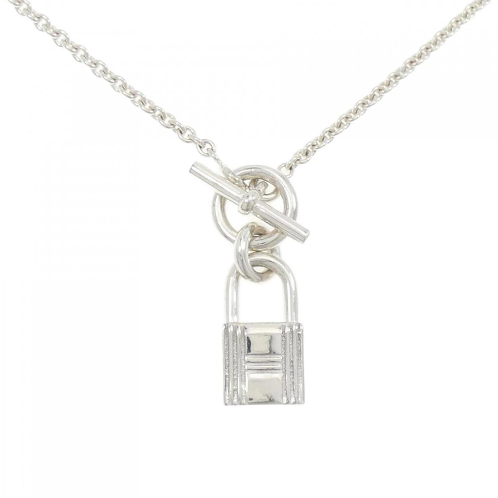 HERMES Silver 925: HERMES Silver 925 Silver 925 pendant from the iconic brand Hermes, featuring a delicate 22.8mm x 10mm design, suspended from a 41 cm chain. Gently used with minor signs of wear, this necklace