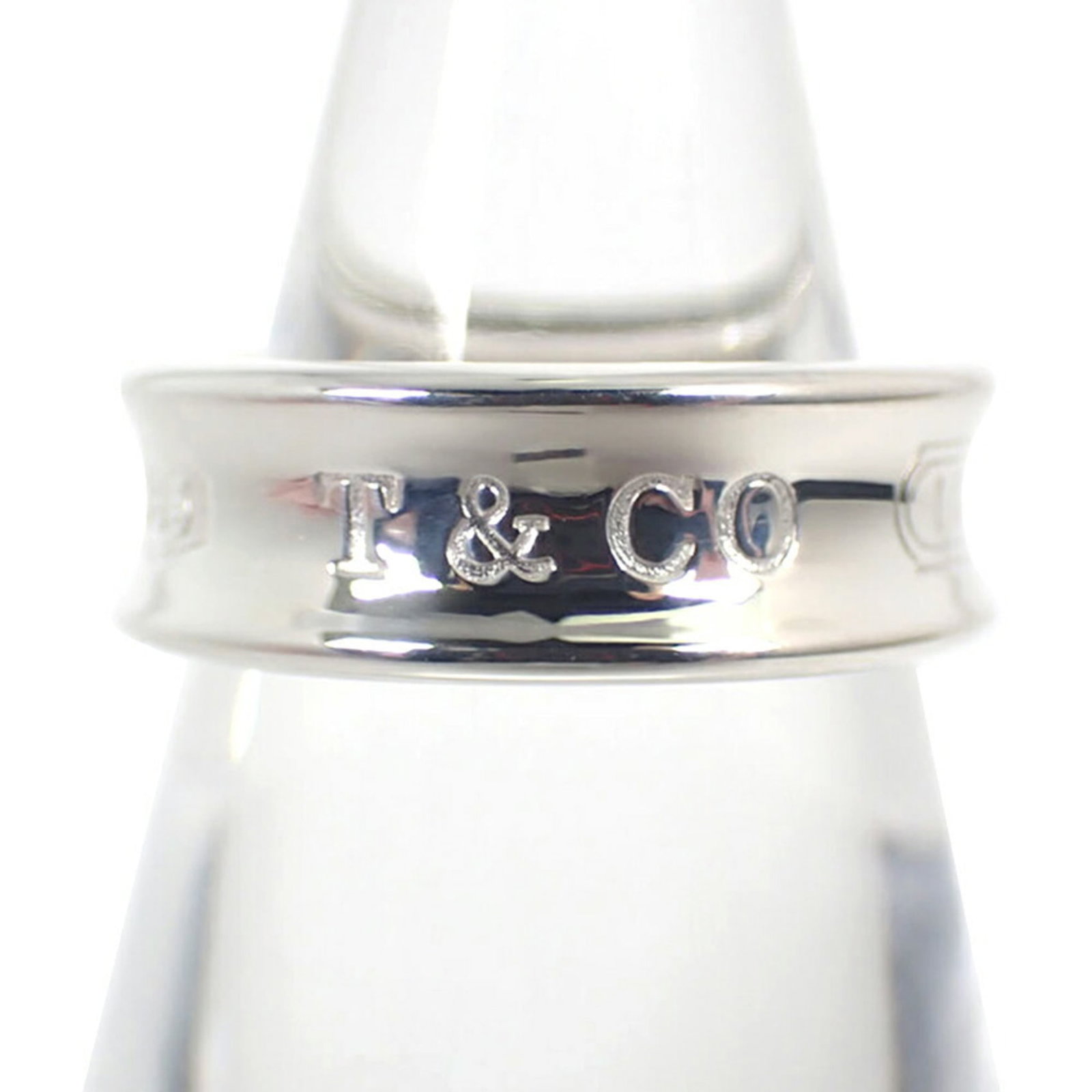 TIFFANY Band Ring Sterling Silver 925: TIFFANY Band Ring Sterling Silver 925 Sterling silver 925 band ring from Tiffany, a classic design with a timeless appeal. The ring features a subtle band with a small scratch or light mark, but
