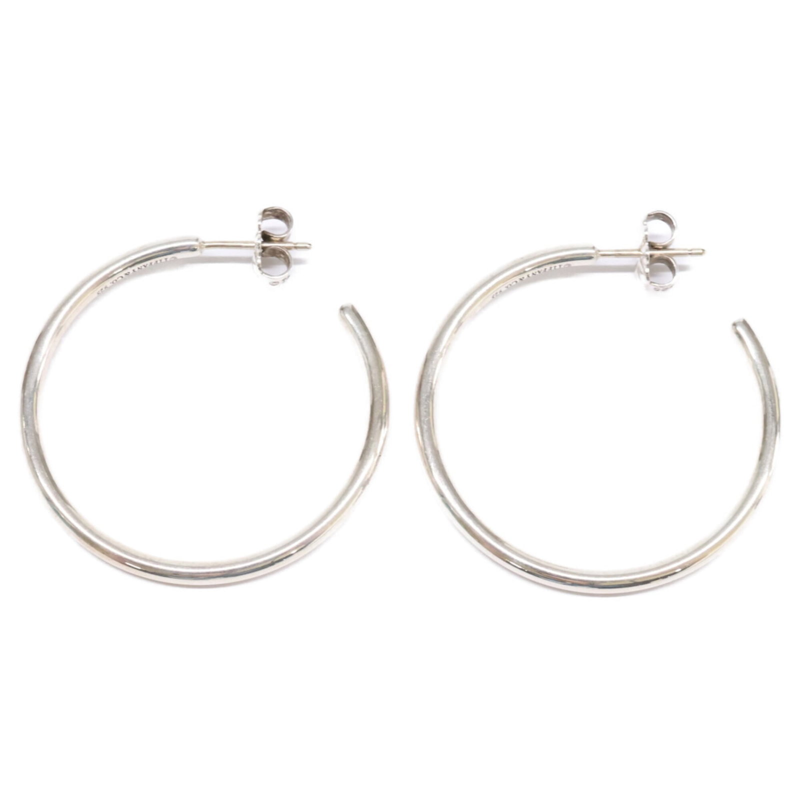 TIFFANY Hoop Earrings Silver 925: TIFFANY Hoop Earrings Silver 925 Silver 925 Tiffany Hoop Earrings with visible scratches and scuffs, offering a unique, pre-owned accessory. Made from durable silver, these earrings provide a classic,