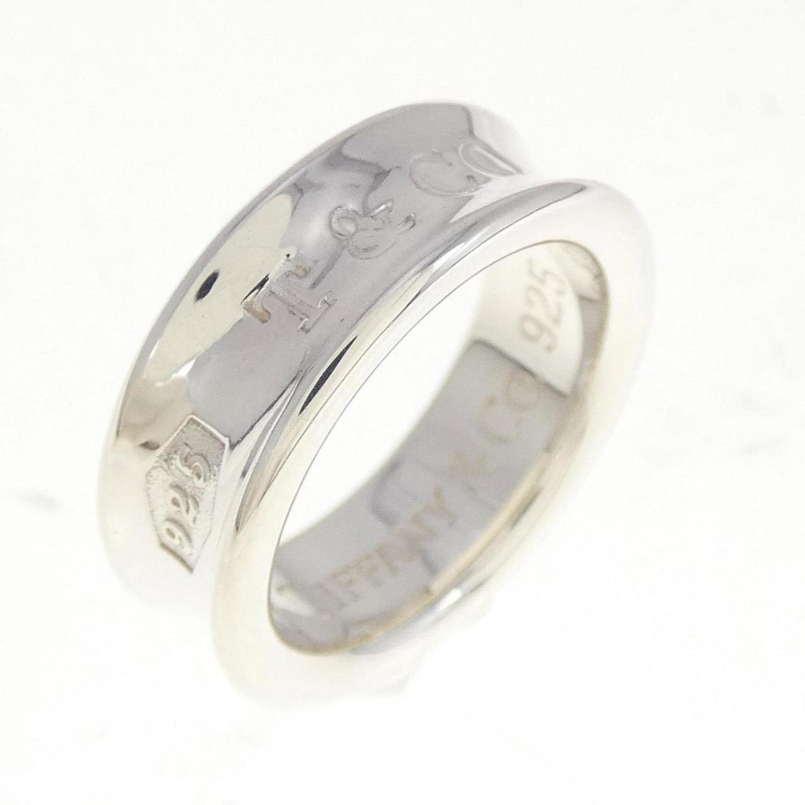 TIFFANY Band Ring Silver 925: TIFFANY Band Ring Silver 925 Silver 925 band ring from Tiffany, a classic women's accessory. This gently used ring features minor scratches and light marks, but remains in very good condition. A small