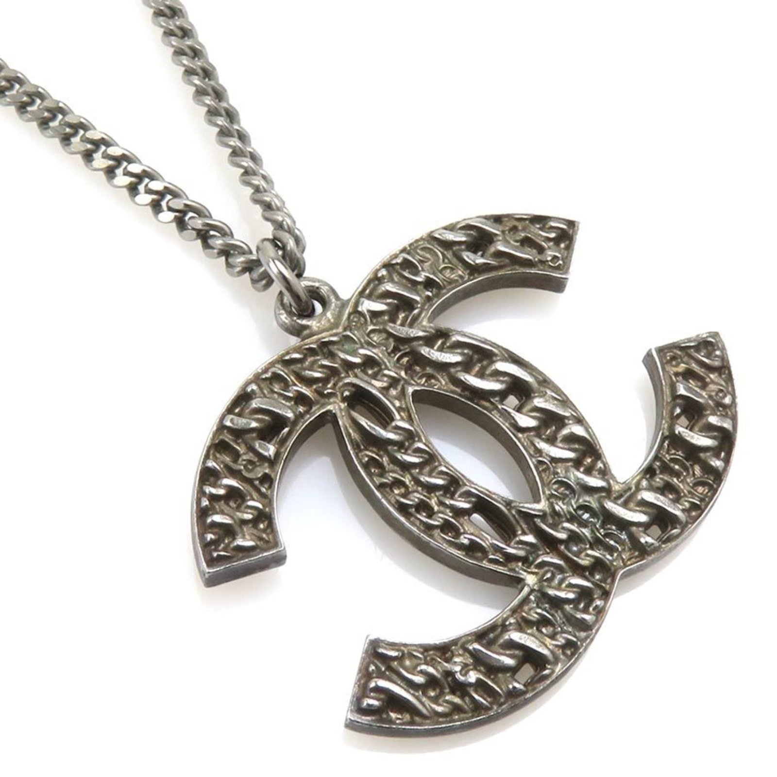 CHANEL Metal Gunmetal: CHANEL Metal Gunmetal Gunmetal finish adds a touch of edgy sophistication to this Chanel metal necklace, featuring a large pendant with a 122mm x 130mm size. The necklace is designed to fit a range