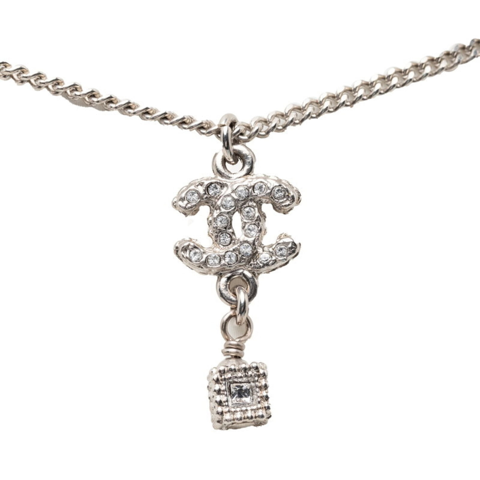 CHANEL Metal Rhinestone: CHANEL Metal Rhinestone Silver Chanel Metal Rhinestone Necklace with Visible Wear. This 60cm silver necklace features a 22.9mm x 11.9mm rhinestone pendant and is made of metal with visible scratches, 