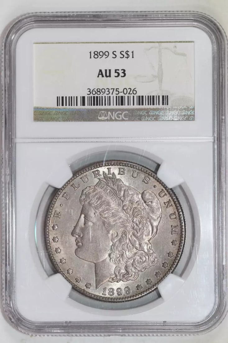 1899-S MORGAN DOLLAR NGC AU53: 1899-S MORGAN DOLLAR NGC AU53 The 1899-S Morgan Dollar is a highly detailed and intricately designed coin, bearing the signature of its artist, George T. Morgan. Made from silver, this circulated coin