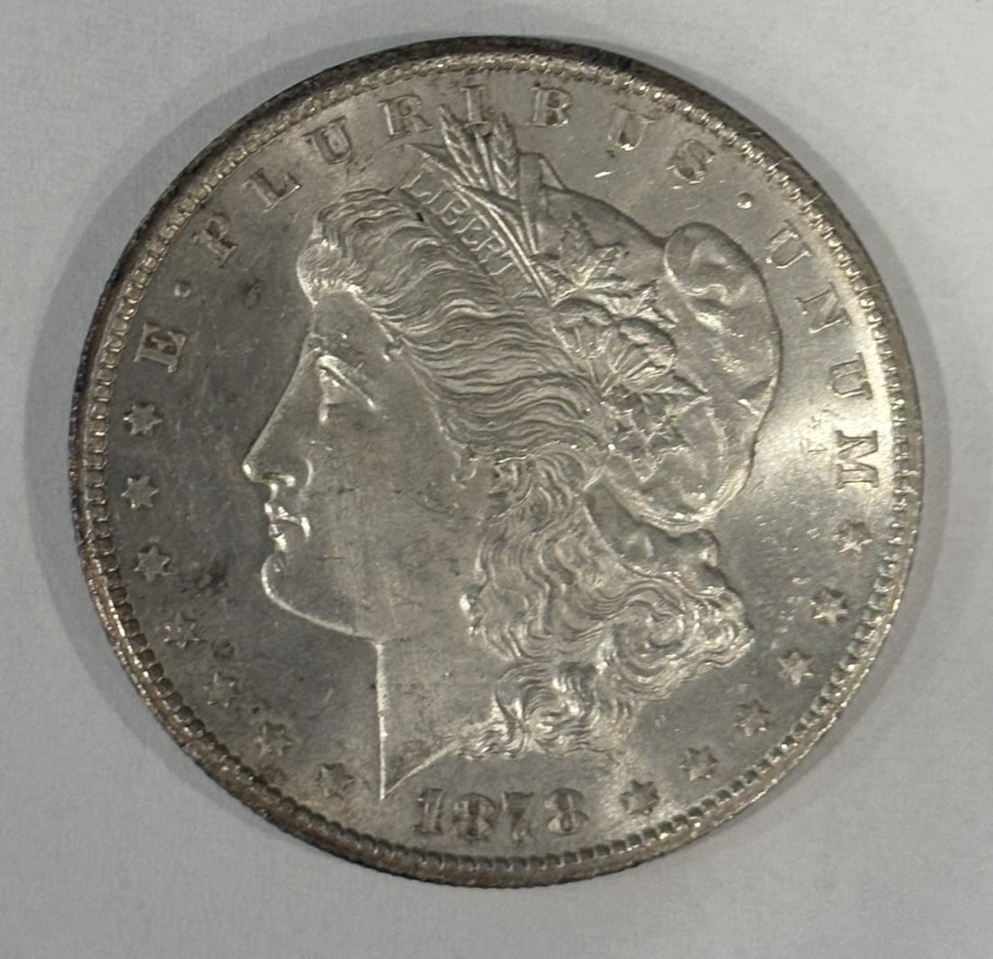 DOLLAR MORGAN CC AU/ BU SLIDER 1878: DOLLAR MORGAN CC AU/ BU SLIDER 1878 The 1878 $1 Dollar Morgan CC AU/BU Slider is a high-quality example of a Carson City minted coin, featuring a silver composition and a distinctive design. With its 