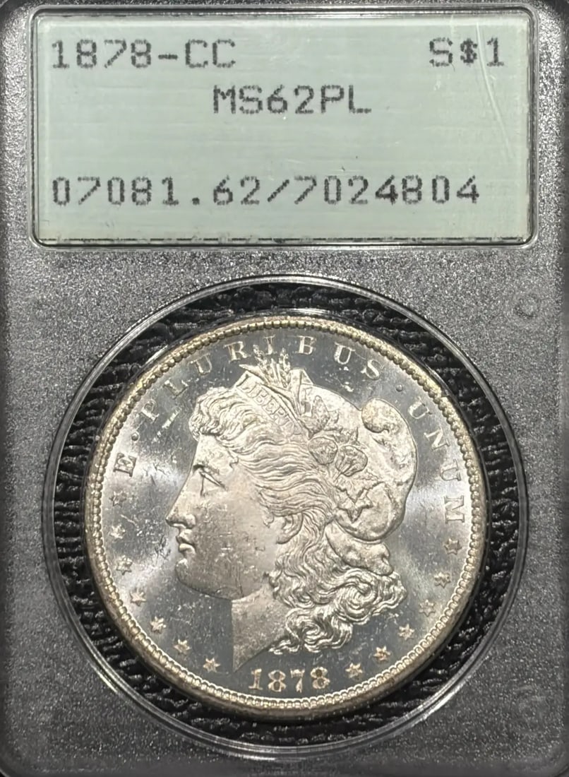1878-CC MORGAN DOLLAR MS62 PL RATTLER OGH: 1878-CC MORGAN DOLLAR MS62 PL RATTLER OGH The 1878-CC Morgan Dollar MS62 PL Rat-tail Variety is a highly detailed and intricately designed coin, featuring a striking silver finish and a well-defined e