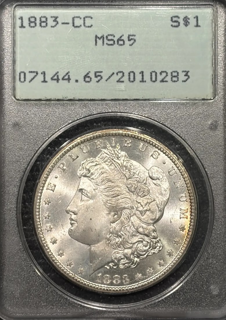 1883-CC MORGAN DOLLAR PCGS MS65 RATTLER OGH: 1883-CC MORGAN DOLLAR PCGS MS65 RATTLER OGH The 1883-CC Morgan Dollar PCGS MS65 Ratlinger OGH is a highly graded, uncirculated coin featuring the iconic design of George T. Morgan. With a PCGS MS 65 g