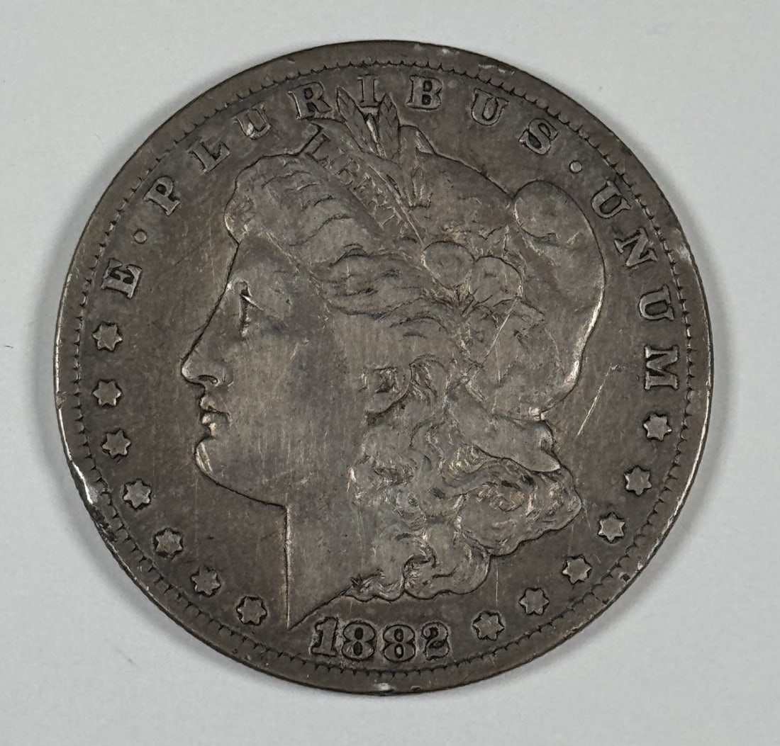 1882-CC MORGAN DOLLAR VF: 1882-CC MORGAN DOLLAR VF The 1882-CC Morgan dollar is a circulated coin with a rich history, bearing the mark of the Carson City mint. This coin features the iconic design of Augustus Saint-Gaudens, s