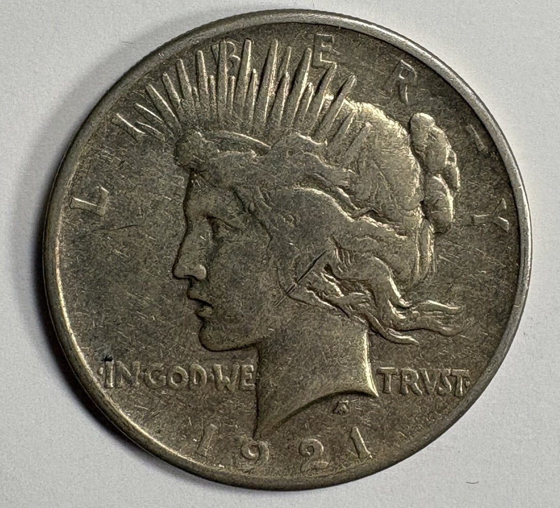 1921 HIGH RELIEF PEACE DOLLAR XF/ AU: 1921 HIGH RELIEF PEACE DOLLAR XF/ AU The 1921 High Relief Peace Dollar features a distinctive design, with a prominent portrait of Lady Liberty on the obverse and a wreath of oak leaves on the reverse