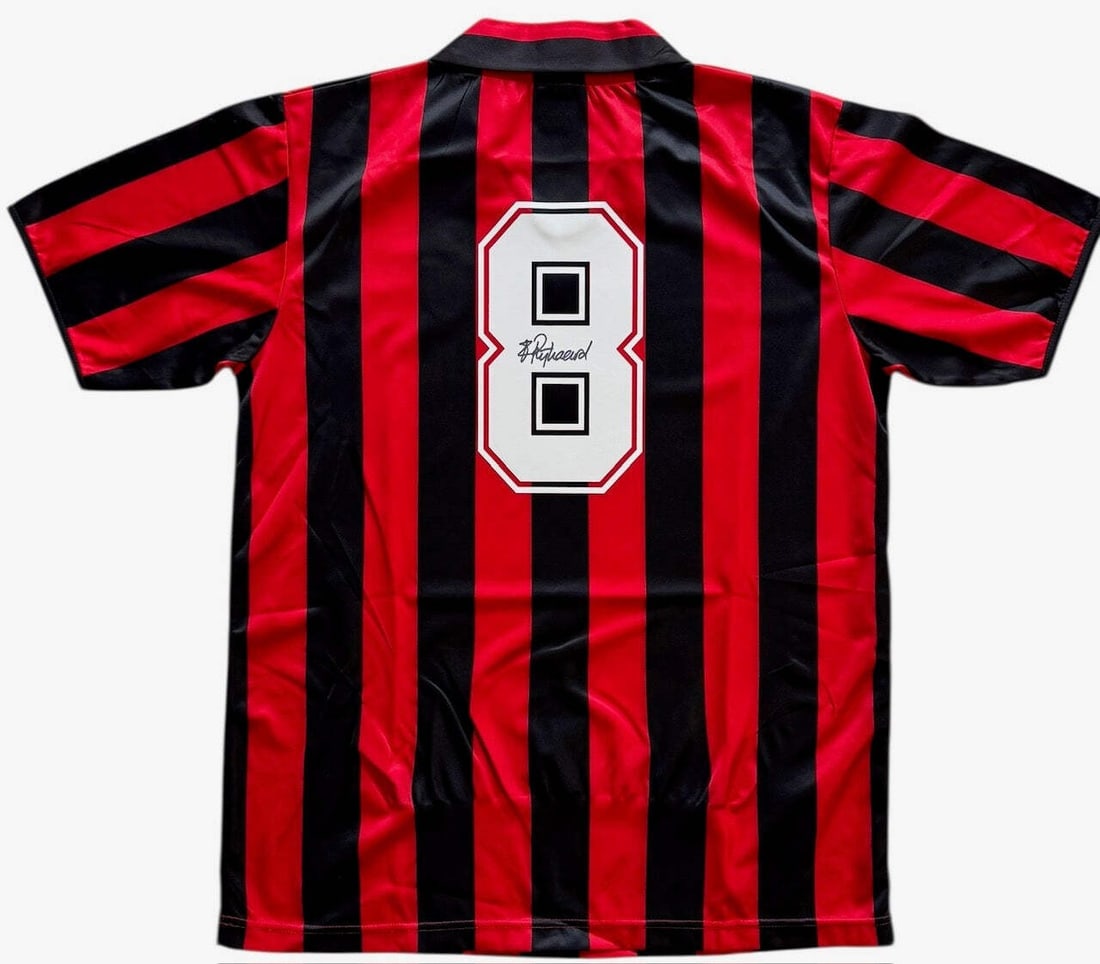 Frank Rijkaard Autographed AC Milan Jersey (Icons): Frank Rijkaard Autographed AC Milan Jersey (Icons) Signed in black sharpie across the back of the jersey, this Frank Rijkaard Autographed AC Milan Jersey bears a notable signature. The jersey is part 